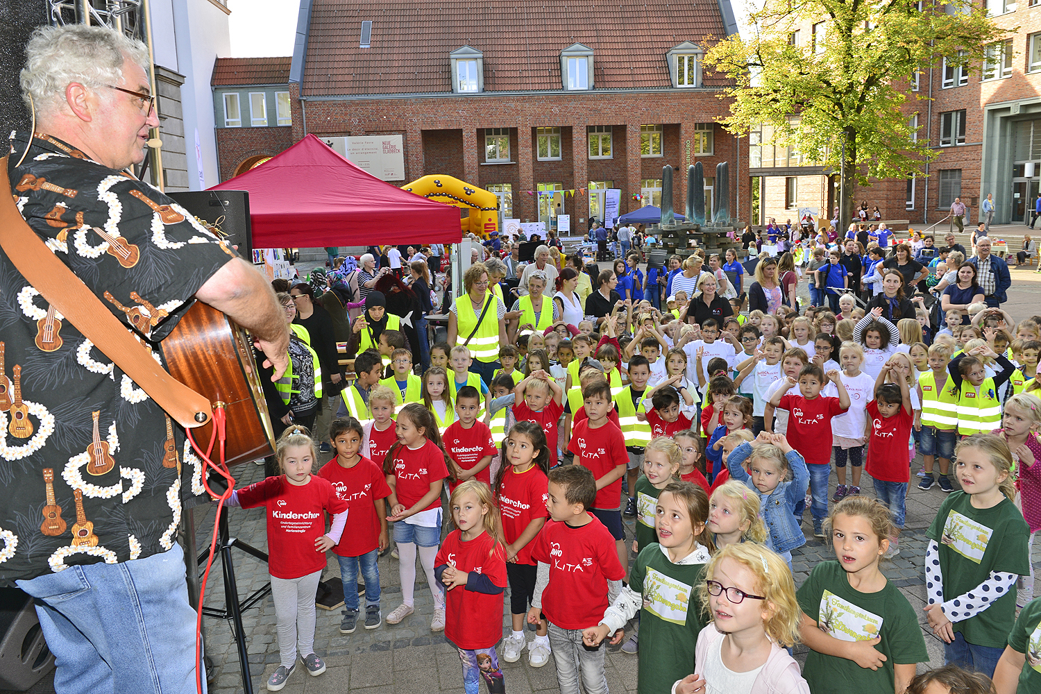 Liedermacher Olaf Wiesten verstand es wieder einmal ausgezeichnet, sein junges Publikum ordentlich zum Mitmachen zu bewegen. Auch die Rollerbahn vom Spielmobil und viele weitere Angebote rundeten den Welltkindertag auf dem Rathausplatz am Riesener-Brunnen ab. Fotos: Stadtspiegel/Kariger