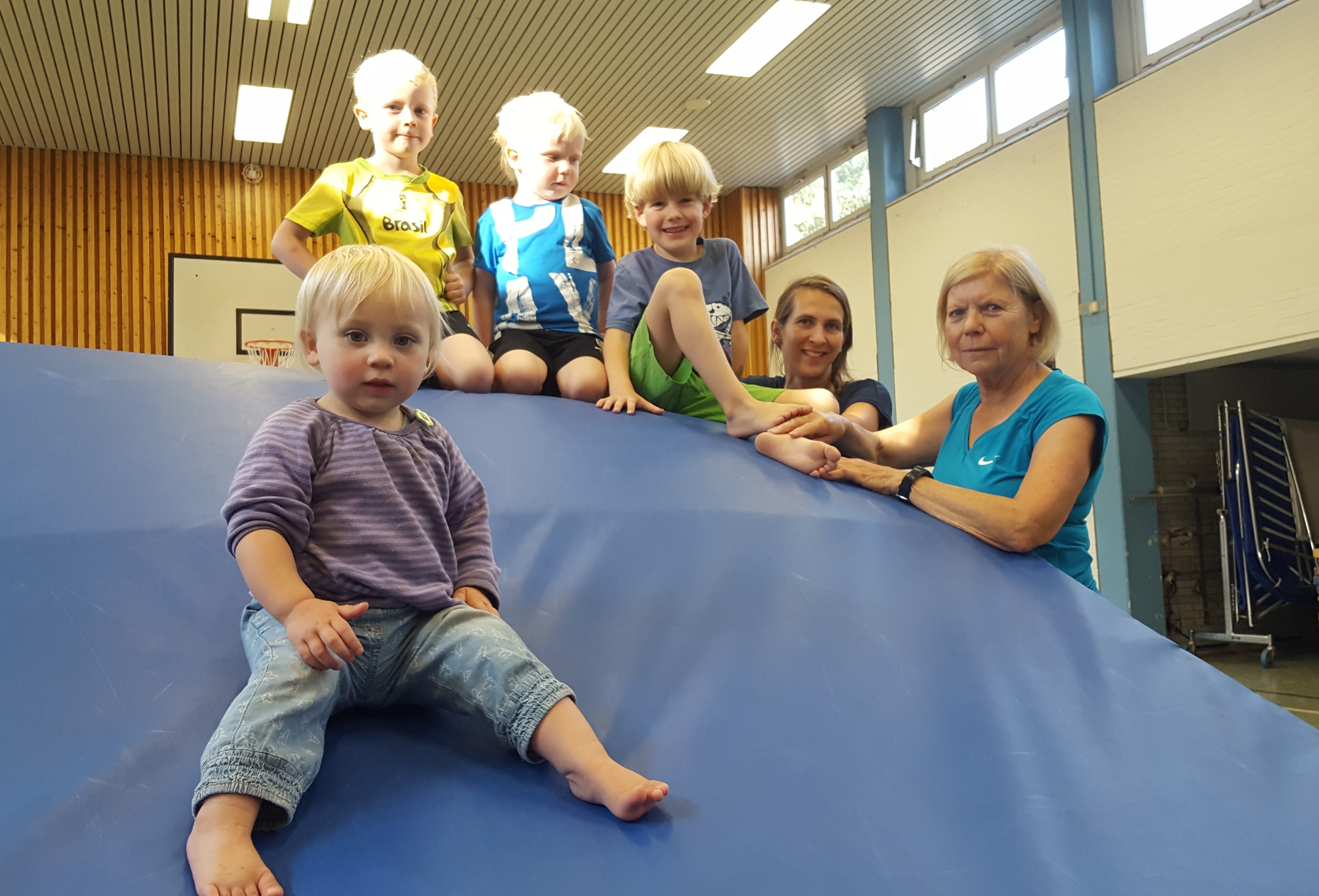 Fröhliche Turnkinder, Henrike Galla und Übungsleiterin Anne Müller beömmeln sich über die kleine Kirsa.
Foto: Henschke