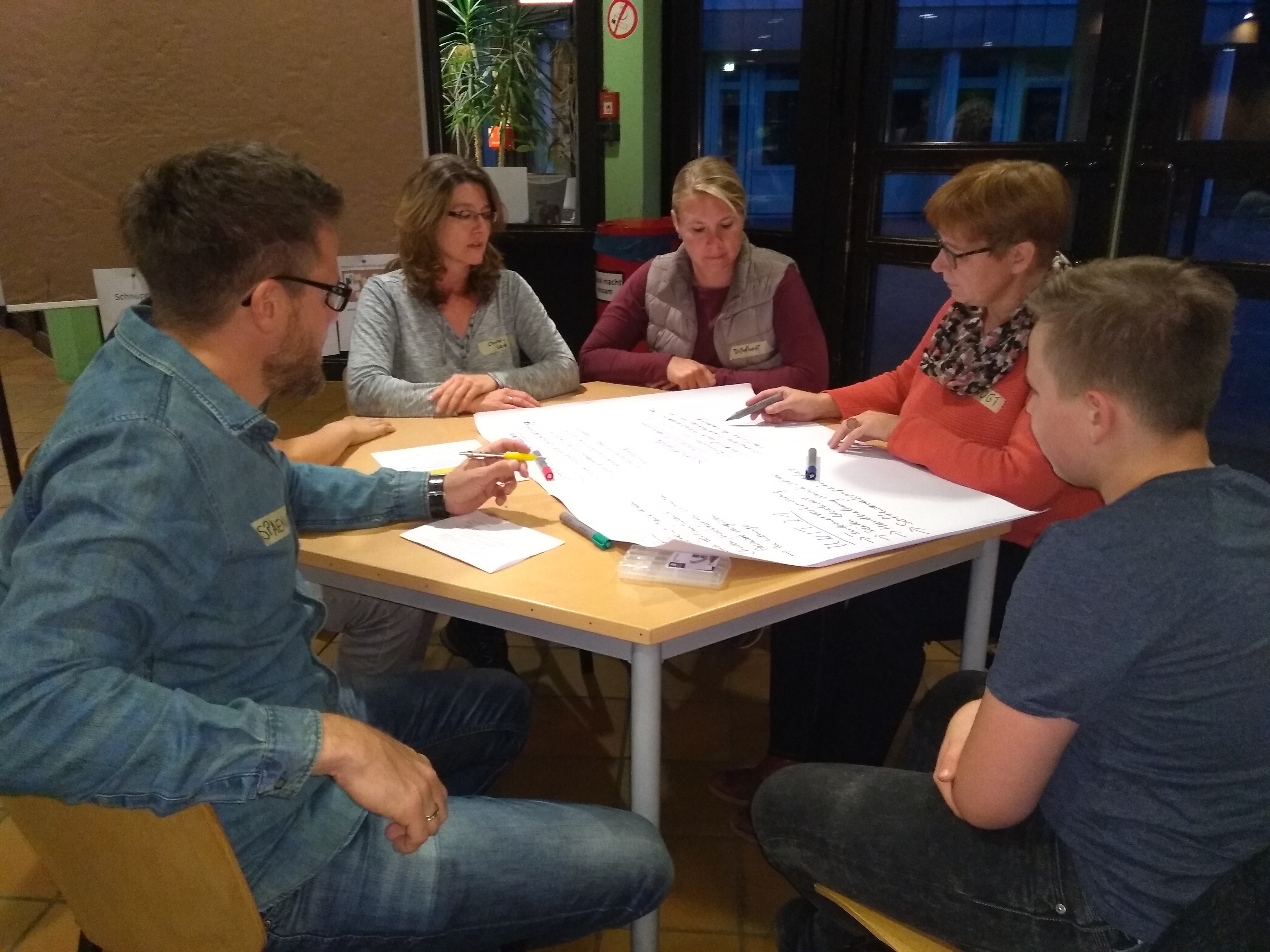 Schüler, Eltern und Lehrer im gemeinsamen Dialog.