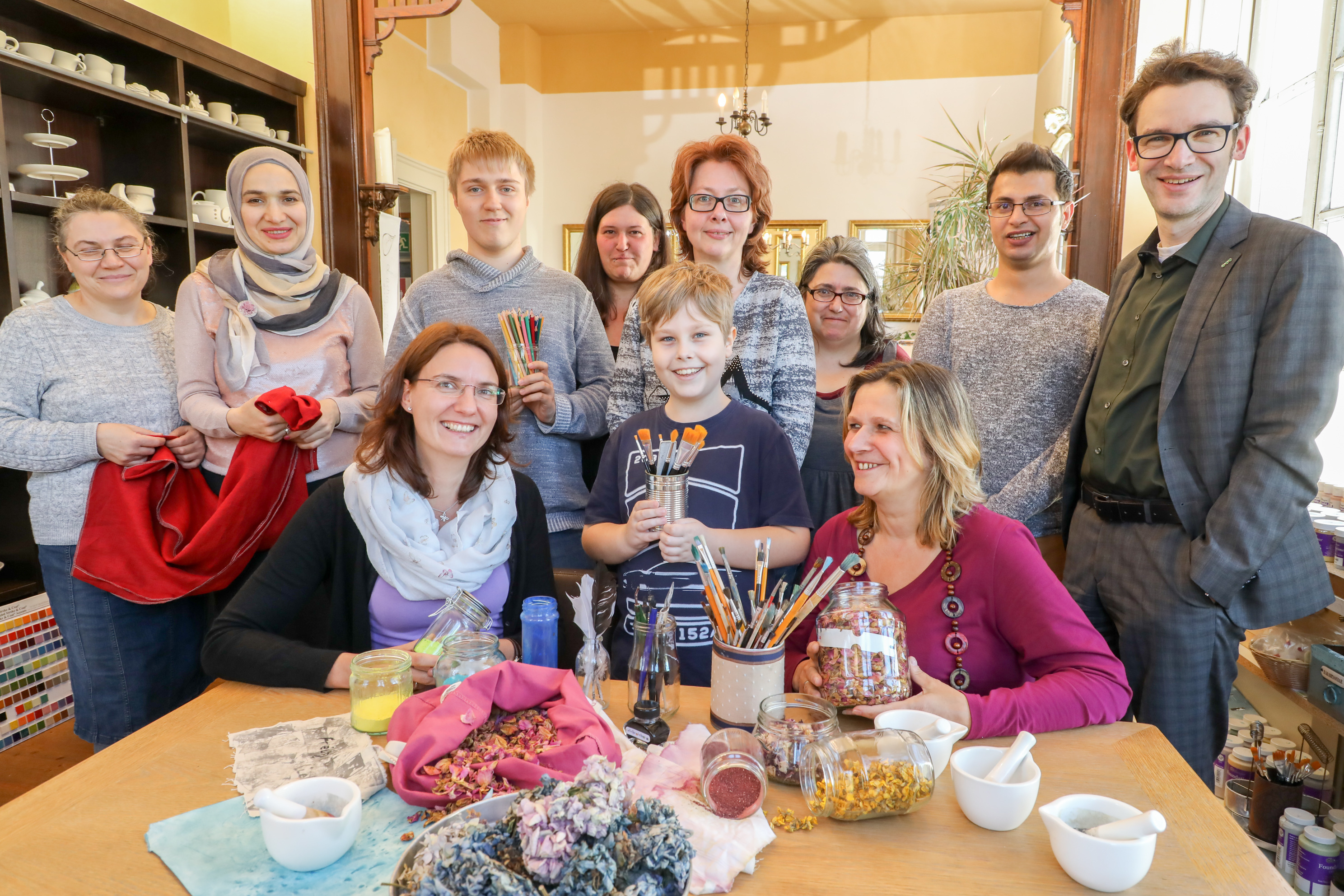 Heike Philipp und Tina Grams (vorne v.r.) mit Ehrenamtlern und Gästen im AtelierSieben. ^Foto: AVU / Bernd Henkel