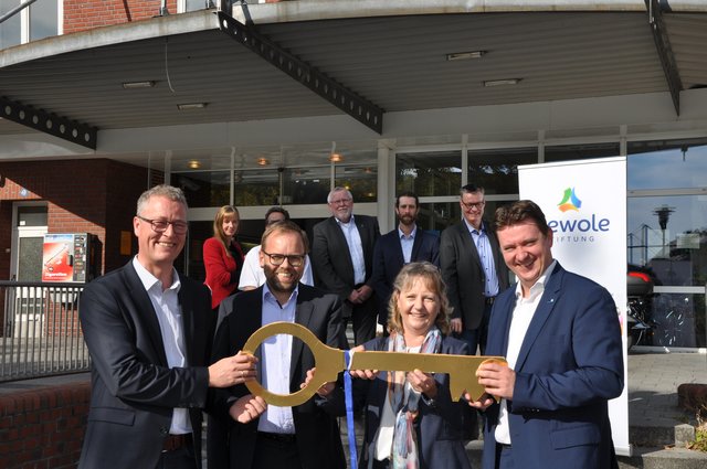 Mit der Schlüsselübergabe von der Deutschen Bahn zur Wewole-Stiftung wurde der Besitzerwechsel am Bahnhofsgebäude offiziell dokumentiert. Die vordere Reihe zeigt (v.l.) Rochus Wellenbrock (Wewole), Carsten Kirchhoff (Bahnflächen-Entwicklungsgesellschaft NRW), Dorothee Wasel (DB Station & Servive) sowie Bürgermeister Rajko Kravanja.