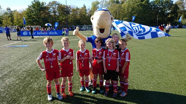 Das Schalker Maskotten "Erwin" mit der Schermbecker U9: Ole Kerkhoff, Johann Werner, Esther Herrschaft, Bengt Ingmar Rosen, Matti Schoch, Liam Schrader und Anton Schneider.