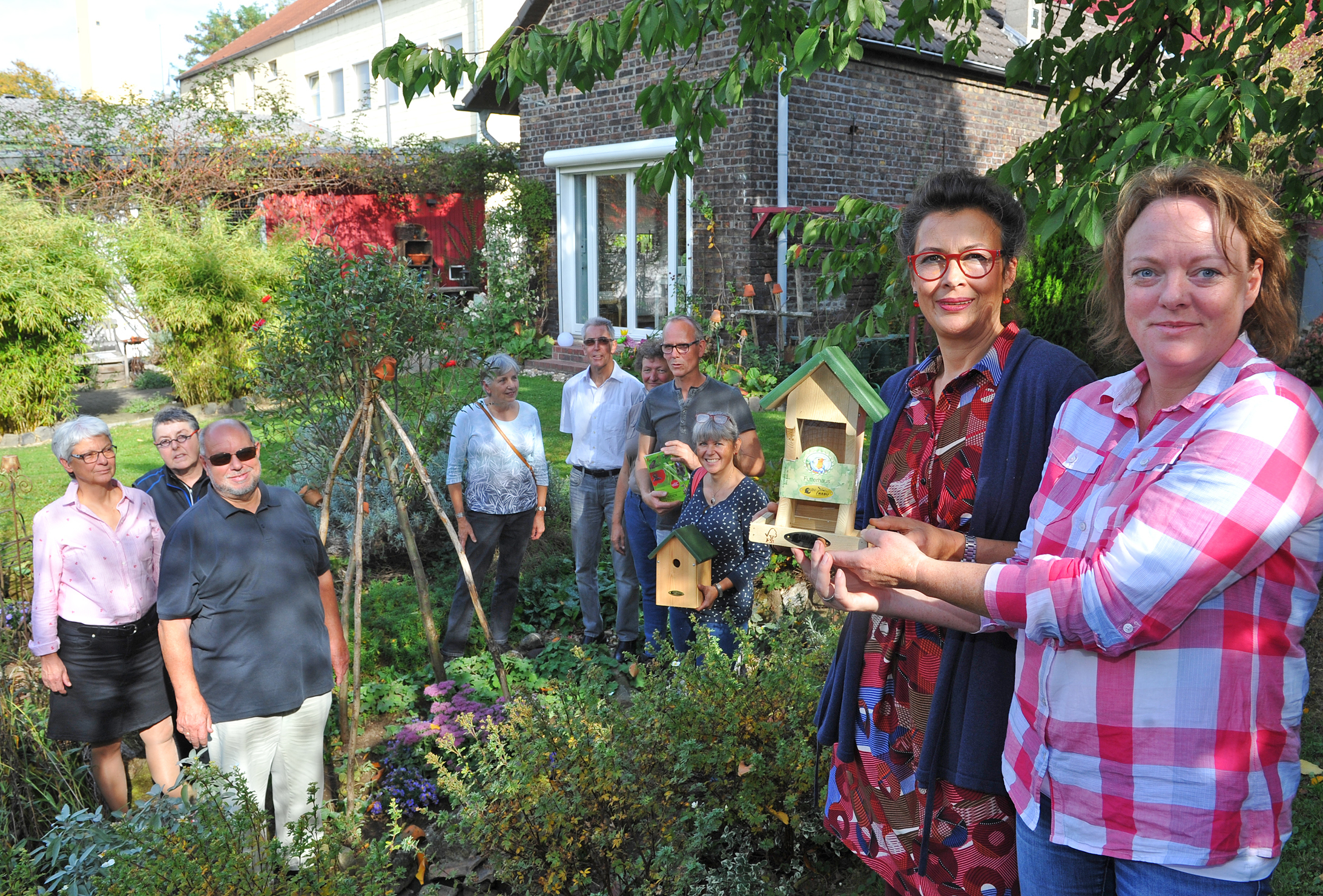 Glückwunsch: Der erste Preis wurde der Gewinnerin Sabine Weise (2.v.r.) im Garten in der Rheindorfer Straße 189 von Verena Wagner (r.) überreicht. Im Hintergrund stehen die Zweit- und Drittplatzierten.