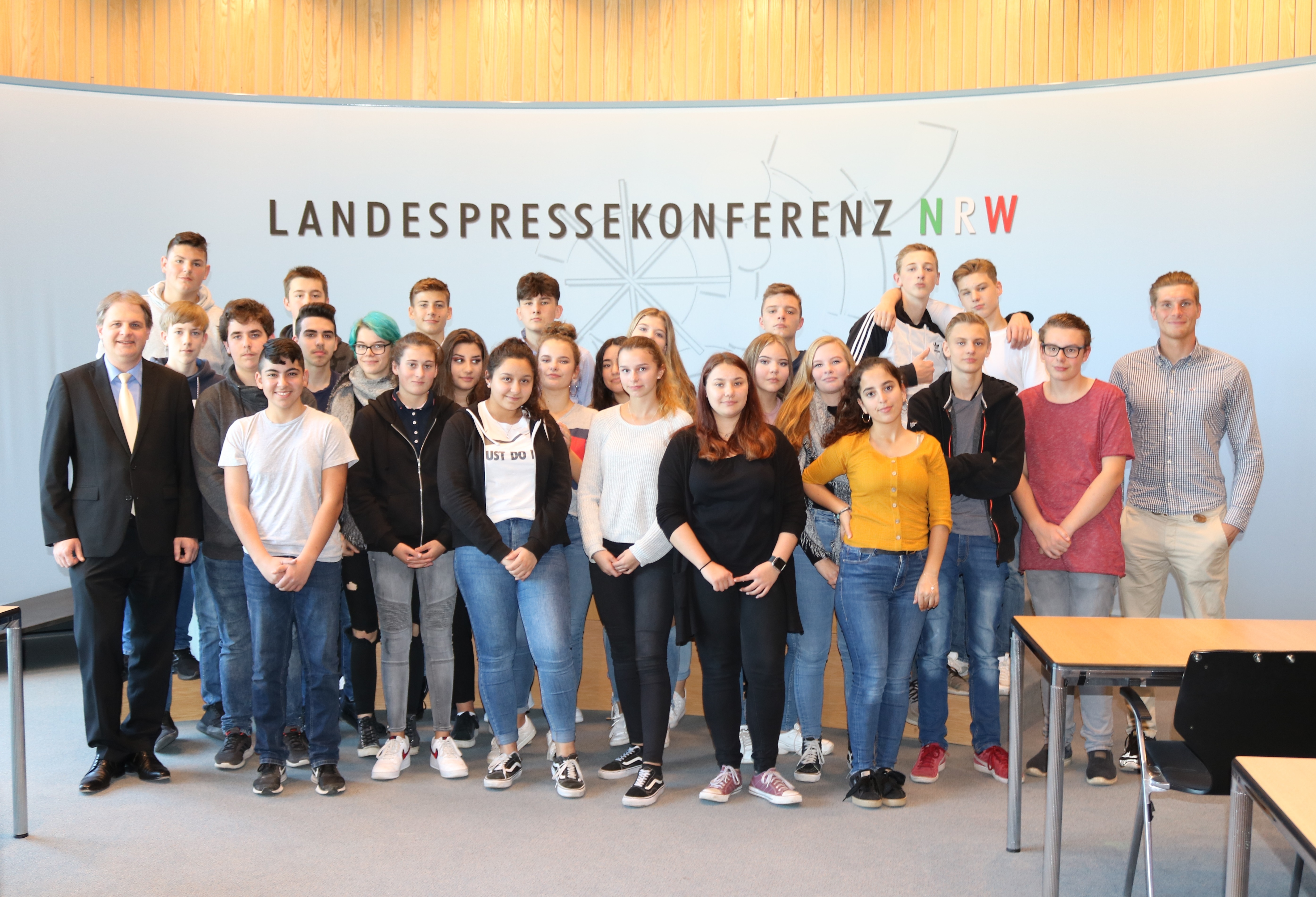 Auf dem Foto ist der 10-er SoWi-Kurs im Saal der Landespressekonferenz mit Ralf Witzel MdL (l.) und Lehrer Steffen Domhöfer (r.). Foto: Annika Beyler/^Landtag NRW 