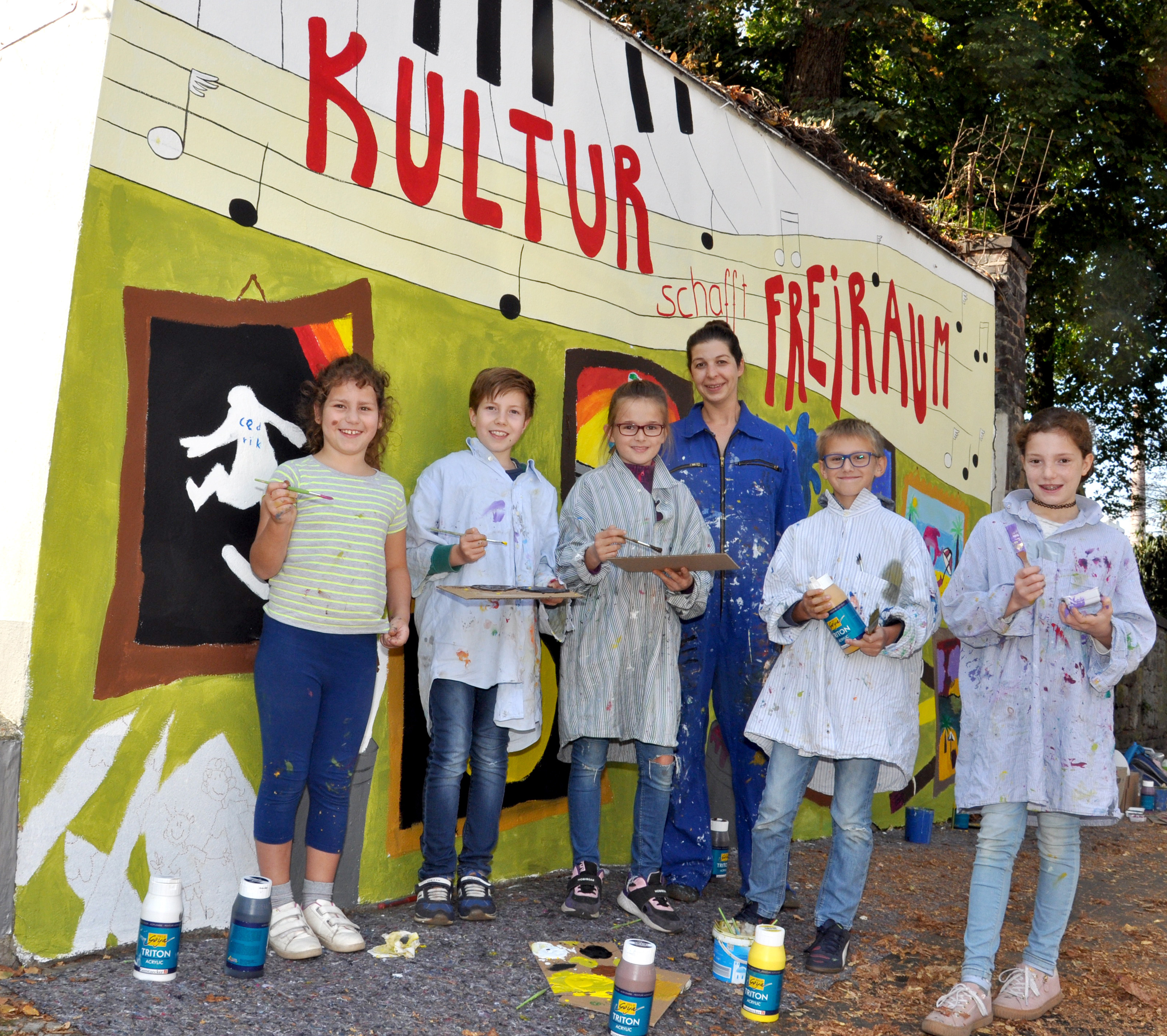 Die kreativ gestaltete Garagenwand in der Schulstraße erinnert an die Künstleraktion "Freiraum - Leerstand". Aktiv daran beteiligt waren die Nachwuchsmaler (v.l.) Franziska, Cedrik. Evelyn. Linus und Sarah. Julia Weber-Seysen (hinten) von der Jugendkunstschule begleitete die kreative Umsetzung.