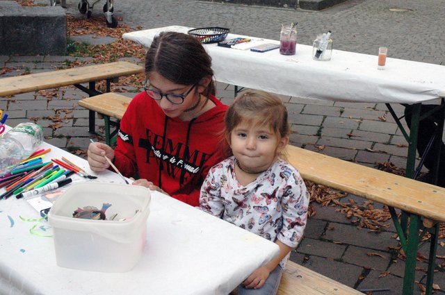 Malen für ein Taubenschlag-Konzept. Feyza hilft der kleinen Zeynab beim Bemalen der symbolischen Taube aus Holz.