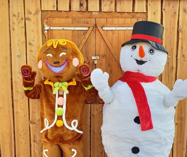 Lebkuchenfigur und Schneemann freuen sich auf das neue Maskottchen.