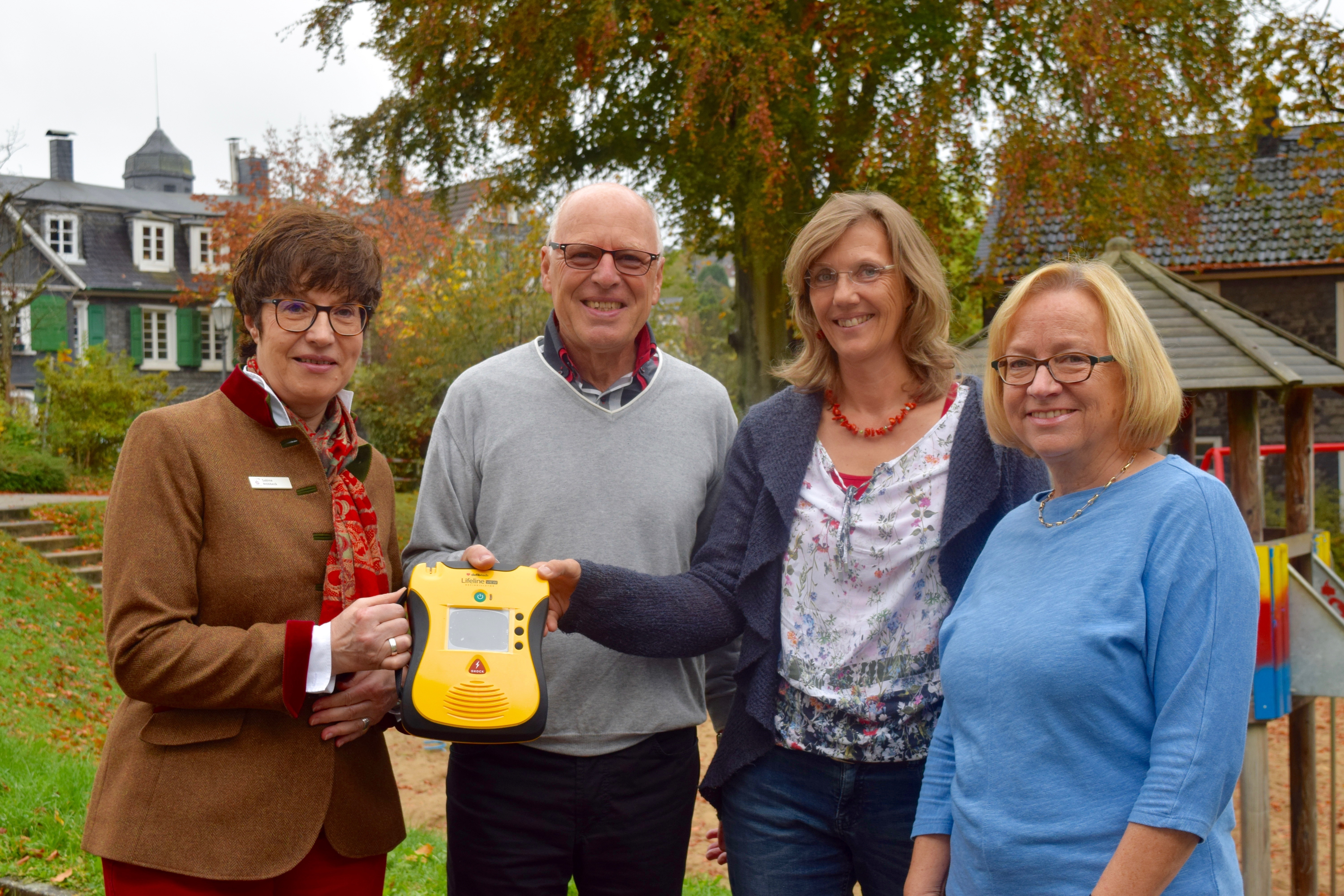 Sabine Möbbeck (von links) von der Sparkasse HRV, Bernd Feldbusch, Geschäftsführer der Langenberger SG, Birgit Koppelmann, zukünftige Leiterin der Kita Wiemhof, und die aktuelle Leiterin Christa Meßelken präsentieren den neuen Defibrillator.