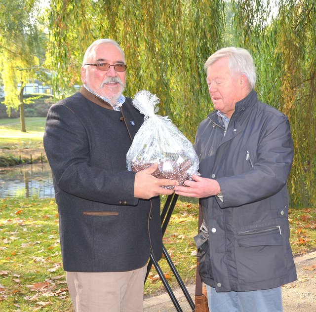 Der ehemalige Ortsvorsteher Willi Vogt (re.) überreichte seinem Nachfolger ein kleines Geschenk: „Diese Seerosen sollen helfen, den Teich zu buntem Leben zu erwecken.“ Foto: peb