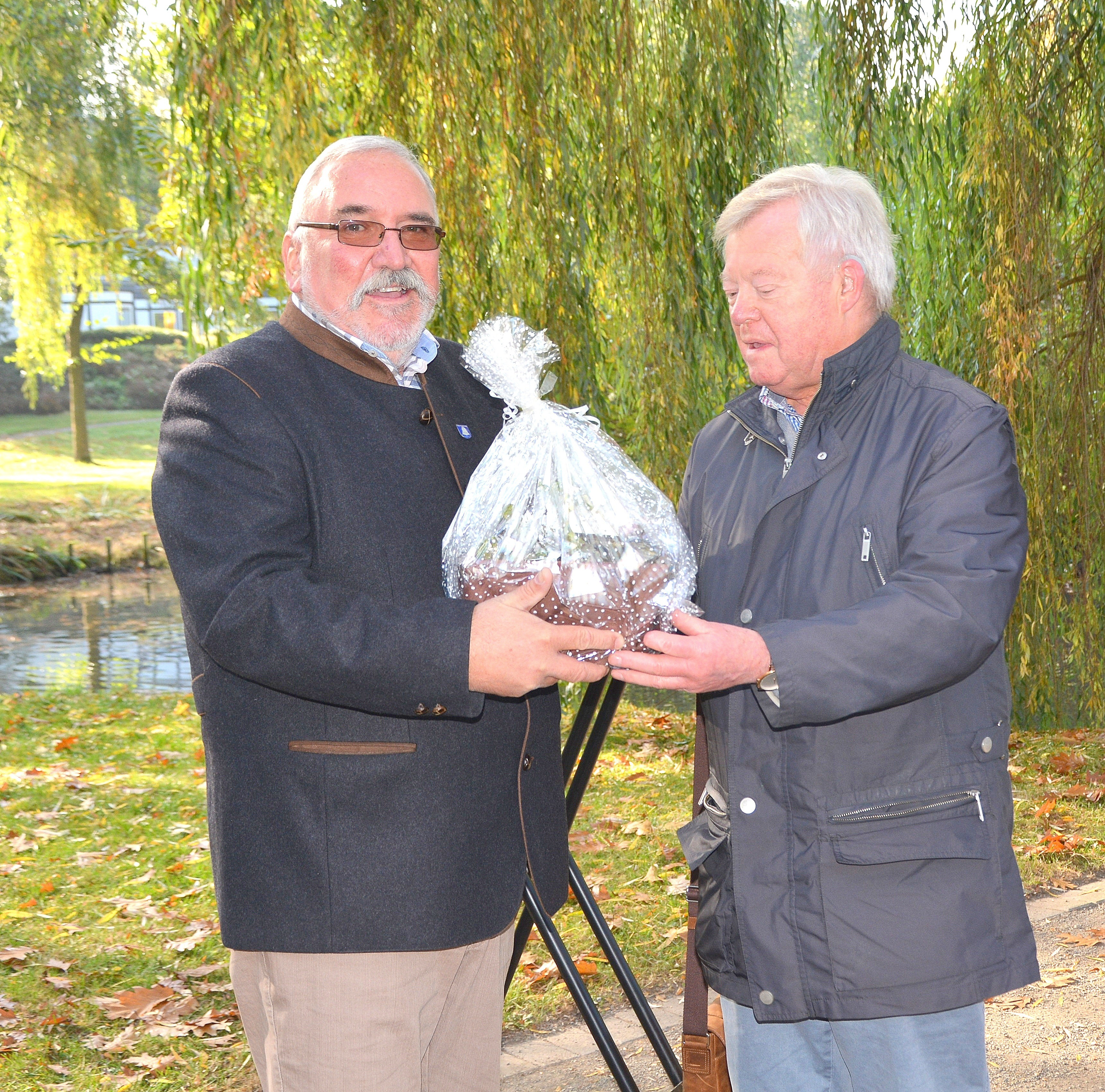 Der ehemalige Ortsvorsteher Willi Vogt (re.) überreichte seinem Nachfolger ein kleines Geschenk: „Diese Seerosen sollen helfen, den Teich zu buntem Leben zu erwecken.“ Foto: peb