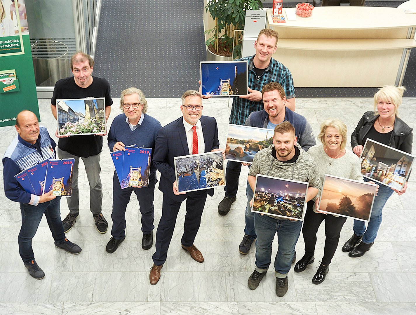 Sieben Fotografen sind im Sparkassen-Kalender für 2019 vertreten: (v.l.) STADTSPIEGEL-Fotograf Siggi Strzysz (Jury), Andreas Brandhoff, Jury-Mitglied Hans-Peter Schuffert (Flash-Foto-Technik & Studio), Jury-Mitglied und Sparkassen-Marketingleiter Udo Schnieders mit dem Foto der nicht anwesenden Fotografin Verena Nottebom, hinten Dominik Bauer (Titelbild), davor Andrè Stuckradt, Ronny Honz, Alexandra Gerlach und Corinna Ackermann. Es fehlt Jury-Mitglied Roland Römer (STADTSPIEGEL-Redakteur). Foto: Groß
