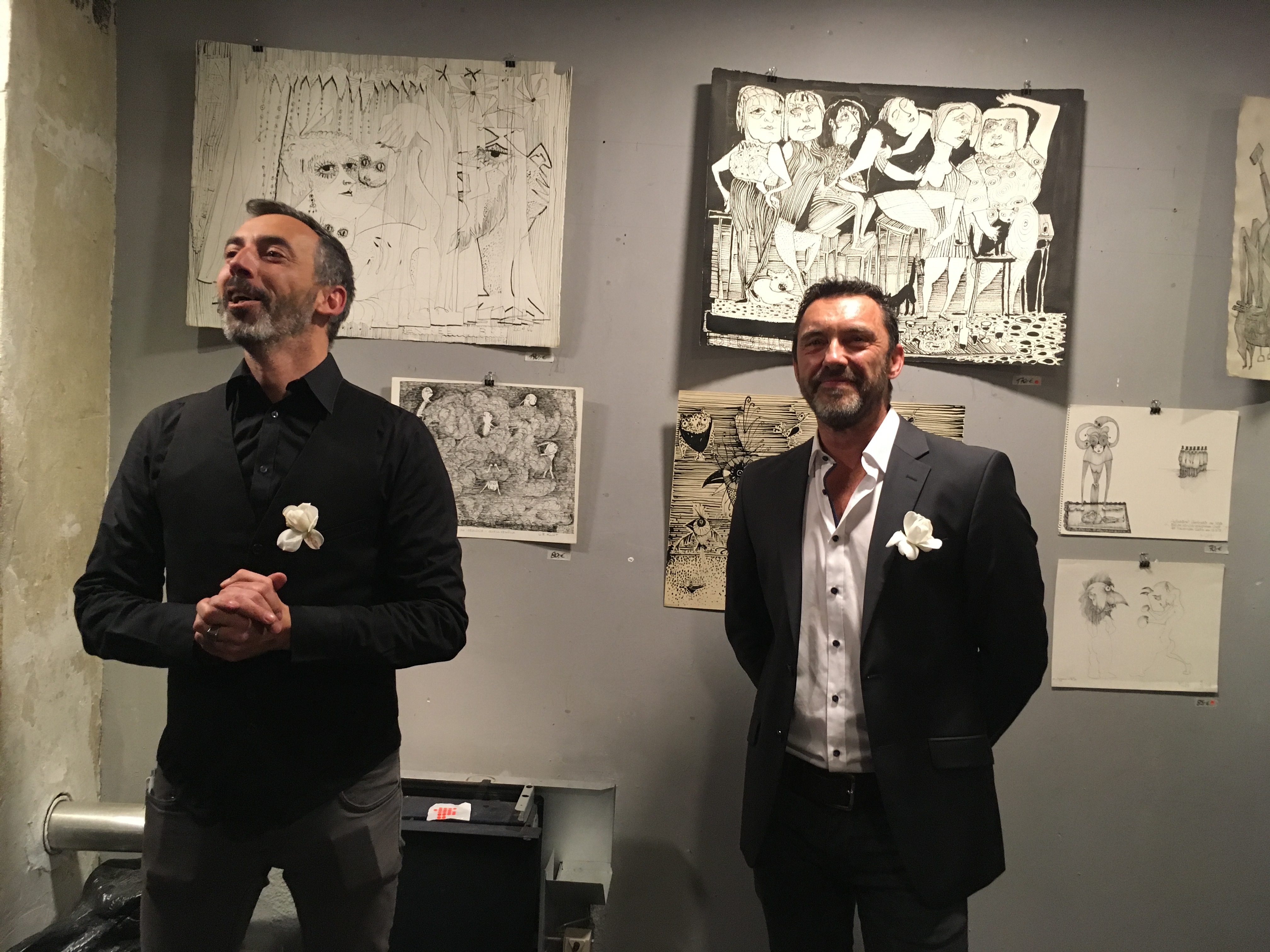 Die Galeristen Jesus Lopez (links) und Christian Brackmann präsentieren Karikaturen von Claus Bernd von Klot.