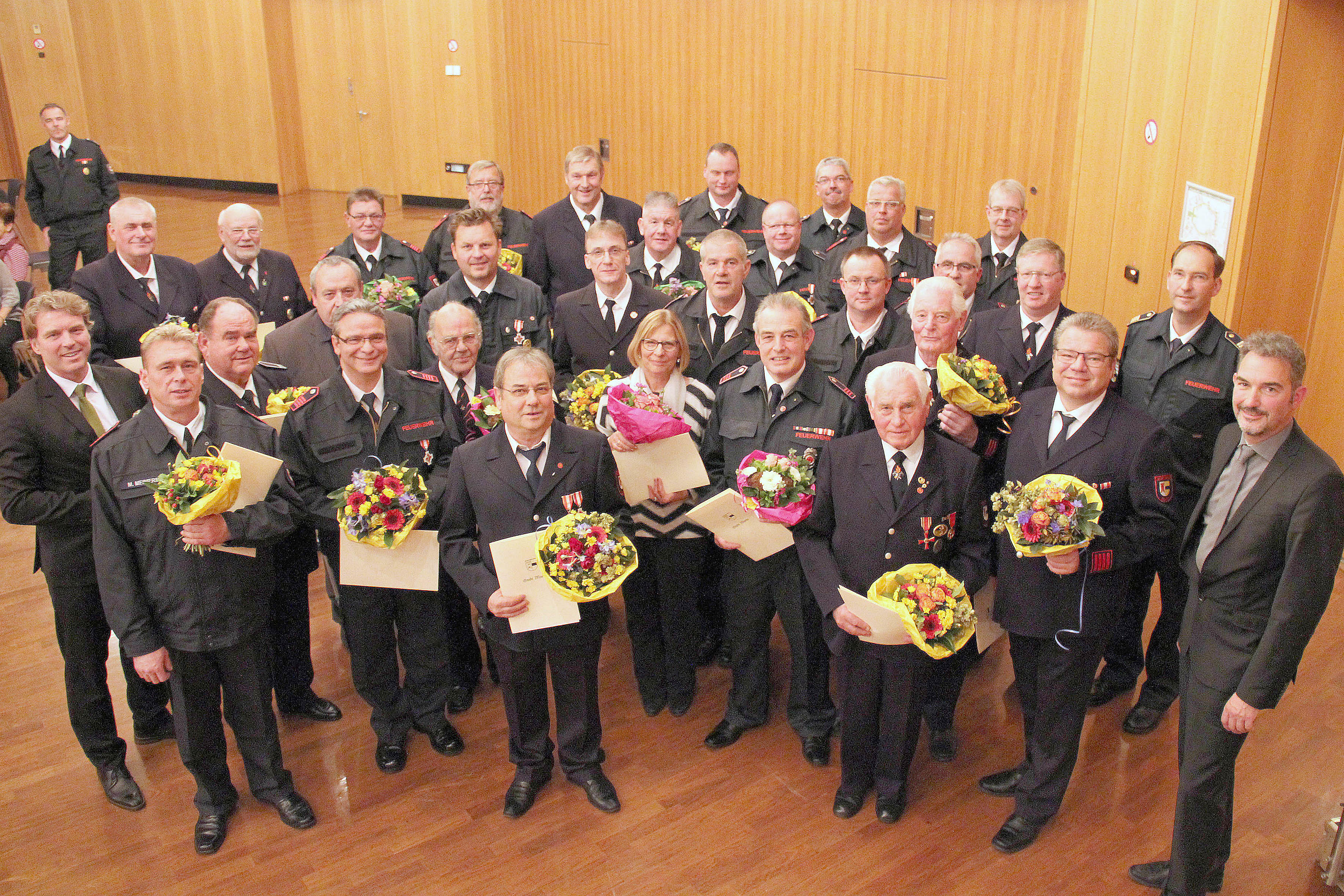 Bürgermeister Christoph Fleischhauer und Christoph Rudolph, Leiter der Feuerwehr, ehrten im Kulturzentrum Rheinkamp verdiente „Blauröcke“. Foto: pst