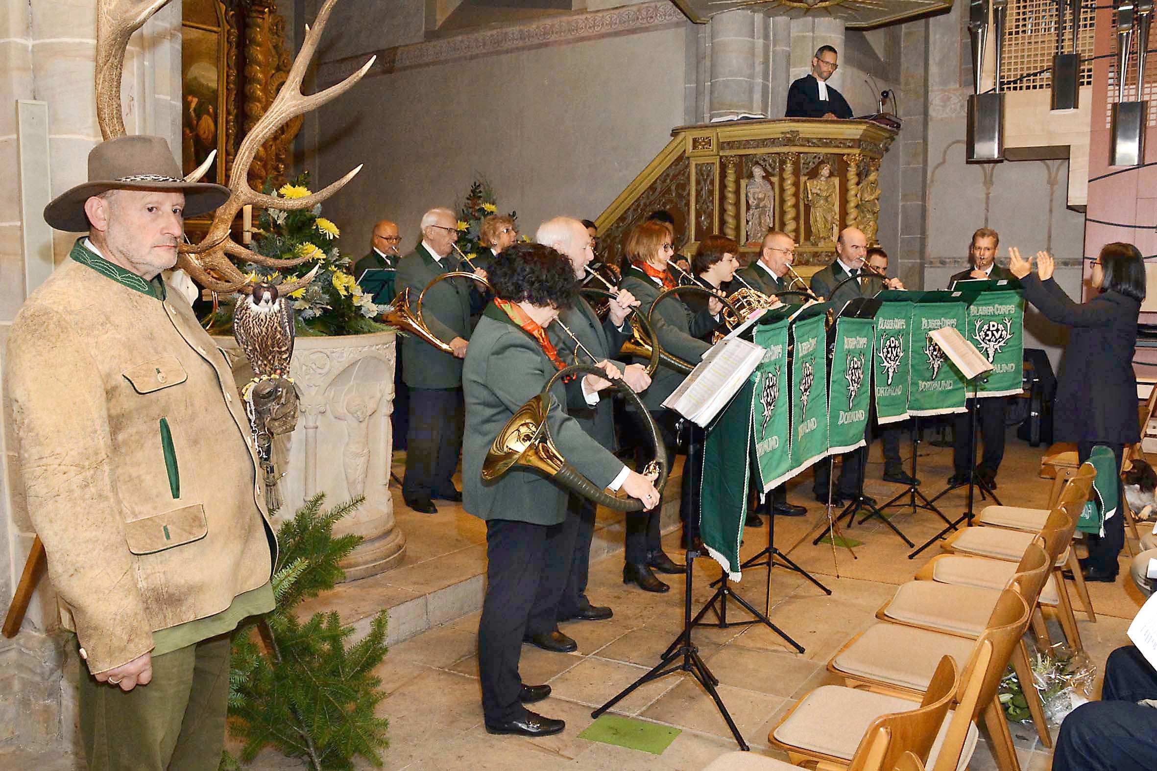 Sogar ein Falkner (links im Bild) mit seinem Tier war vertreten bei der Hubertusmesse in der Brechtener Dorfkirche St. Johann Baptist. Dazu spielten die Bläser des Parforcehorn-Corps der Kreisjägerschaft Dortmund auf. Pfarrer Hanno Gerke (rechts auf der Kanzel) hielt die Andacht.