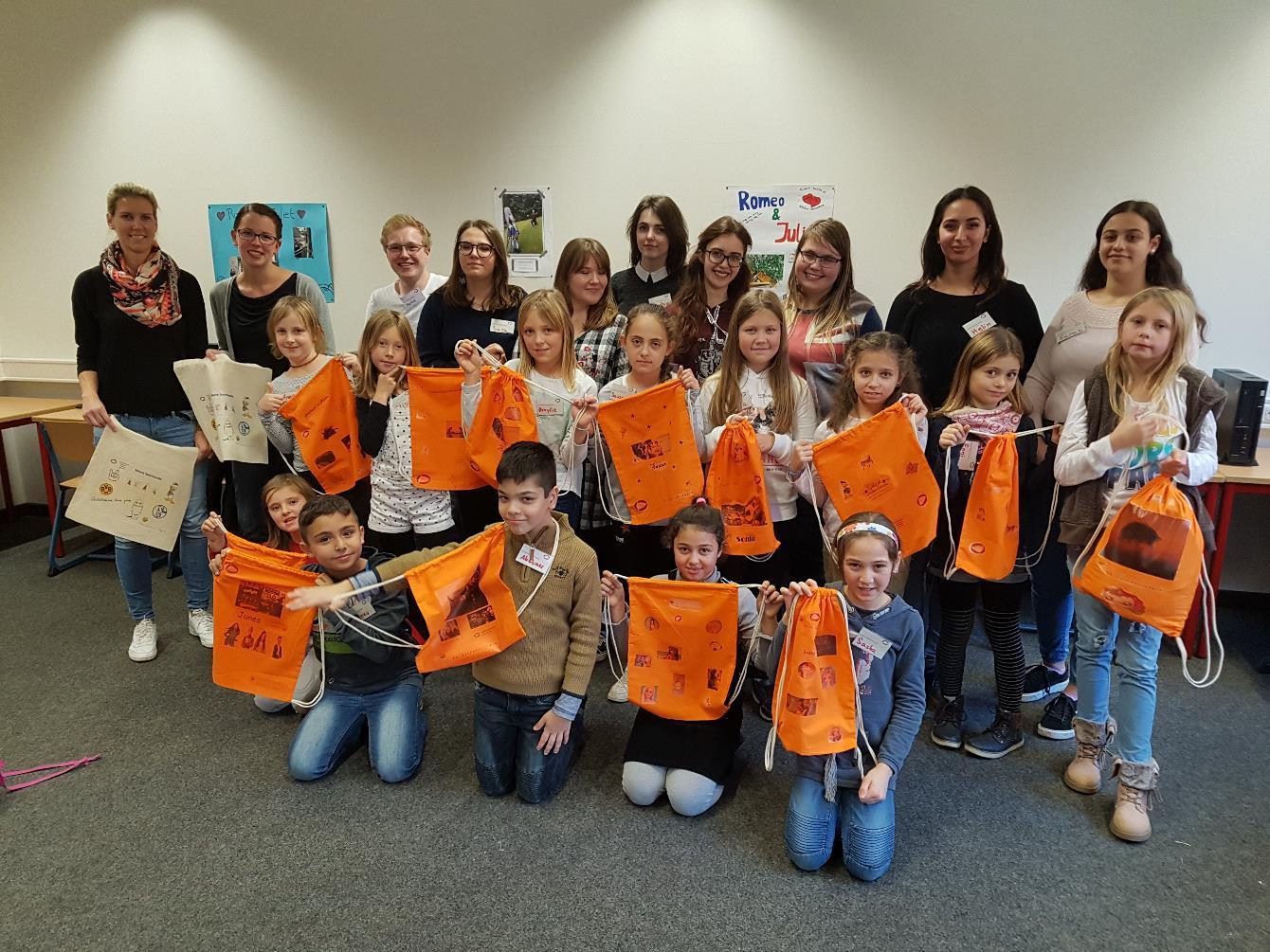 Mit Stolz präsentieren die Pestalozzischülerinnen und -schüler am Ende des Workshops ihre am Computer selbst gestalteten Sportbeutel im frischen Orange. Foto: privat