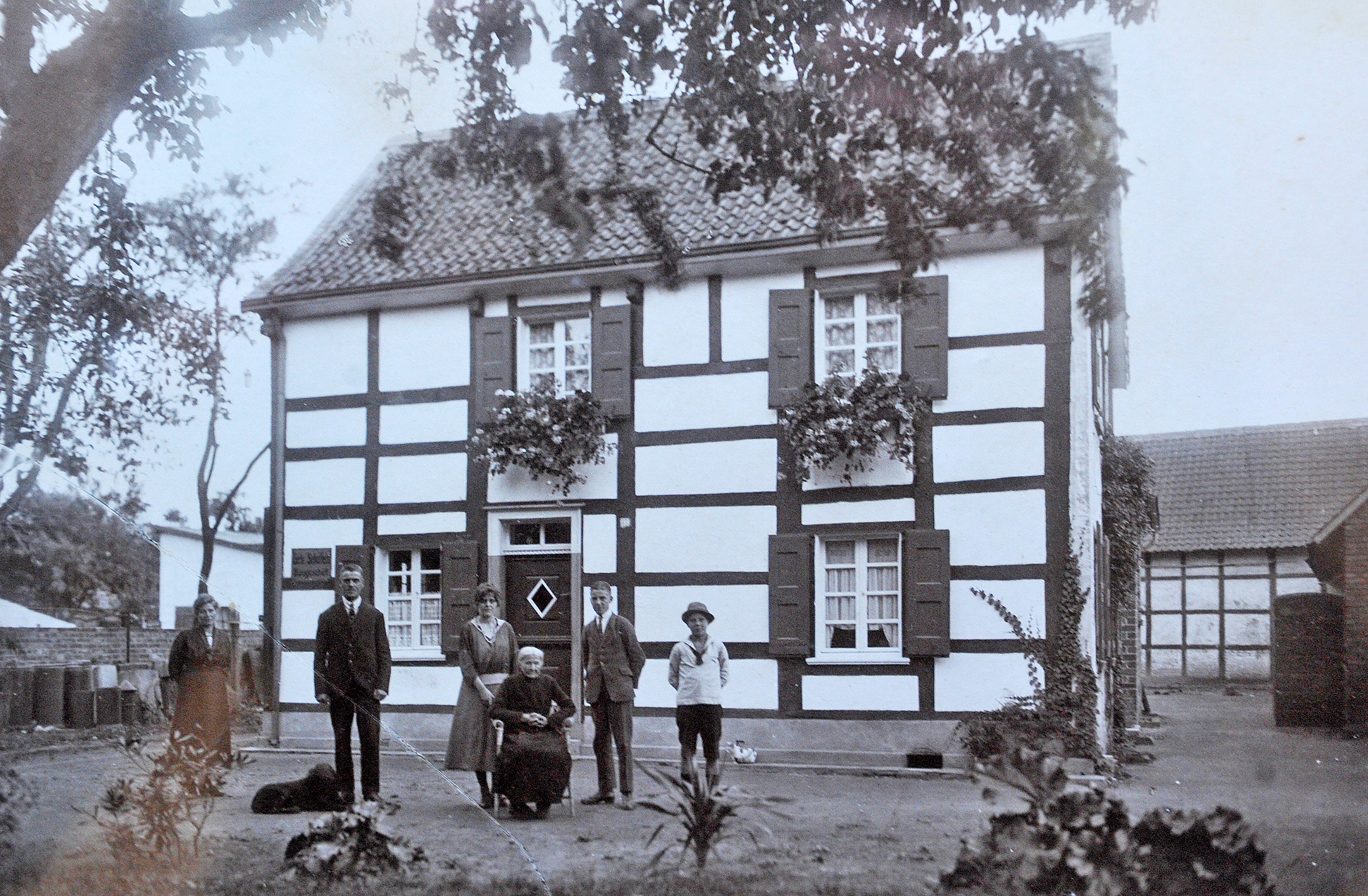 Das Foto zeigt den Firmensitz des "Verlegers und Fabrikanten" Albert Braß, erbaut zirka 1730, war ab 1919 im Besitz des Bauunternehmers Gustav Scheffels, abgerissen 2013. Das Grundstück ist bis heute im Familienbesitz. Das Foto entstand auch in diesem Jahr. Vor dem Haus von links aus der Familie Gustav Scheffels (2.v.l.), Großvater von Wendt Scheffels, 2. Vorsitzender der Aktion Immigrather Bürger: Wilhelmine Scheffels, Enne Fink, Wilhelmine Fink, Hans Scheffels und Paul Scheffels.