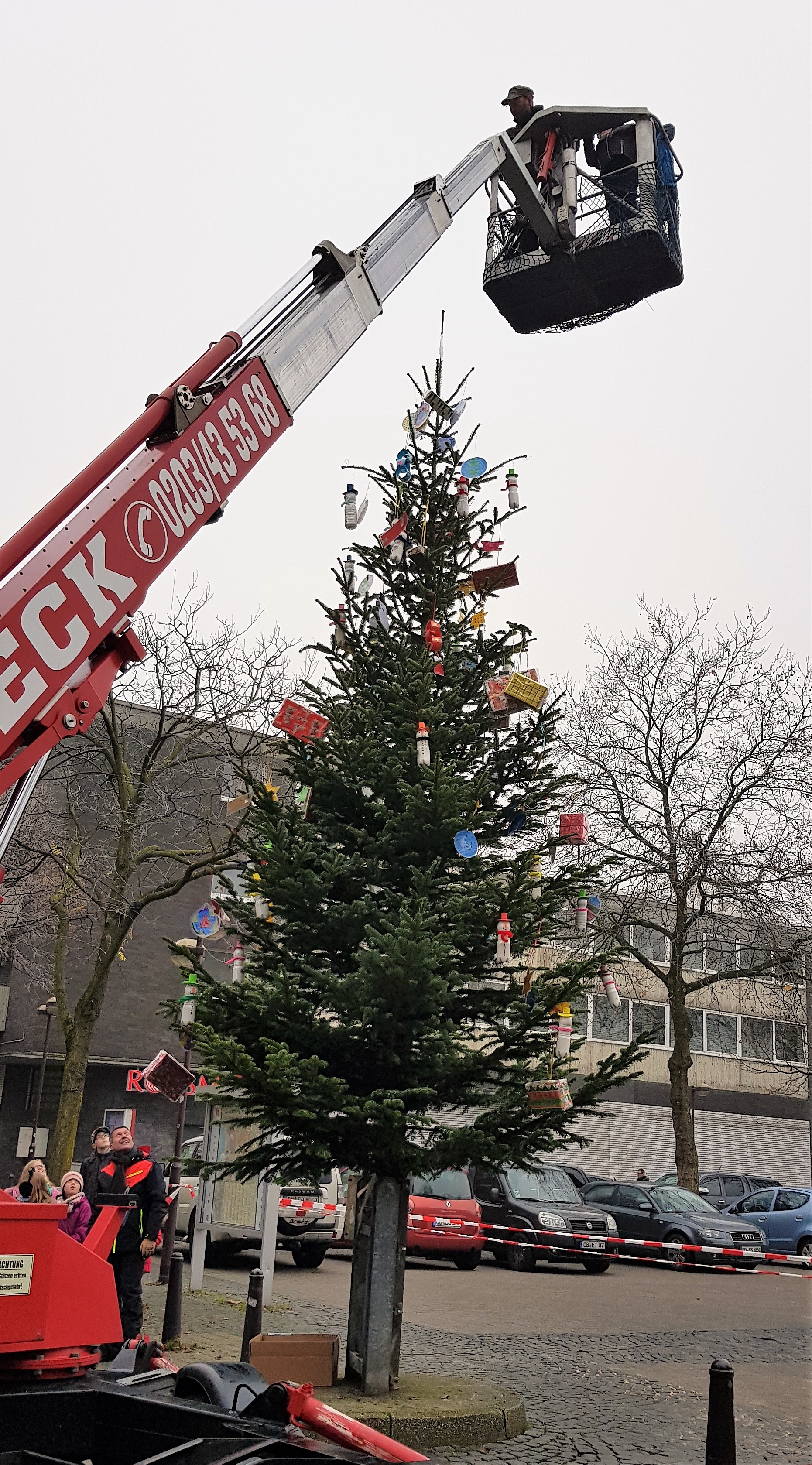 Der traditionelle Neumühler Weihnachtsbaum wird stets mit Mal- und Bastelarbeiten von Kindern und Jugendlichen aus dem Stadtteil festlich geschmückt. Mittels Hubwagen bringt Christian Preuten die Päckchen und Stern wieder an Ort und Stelle.
Foto: R. Terhorst