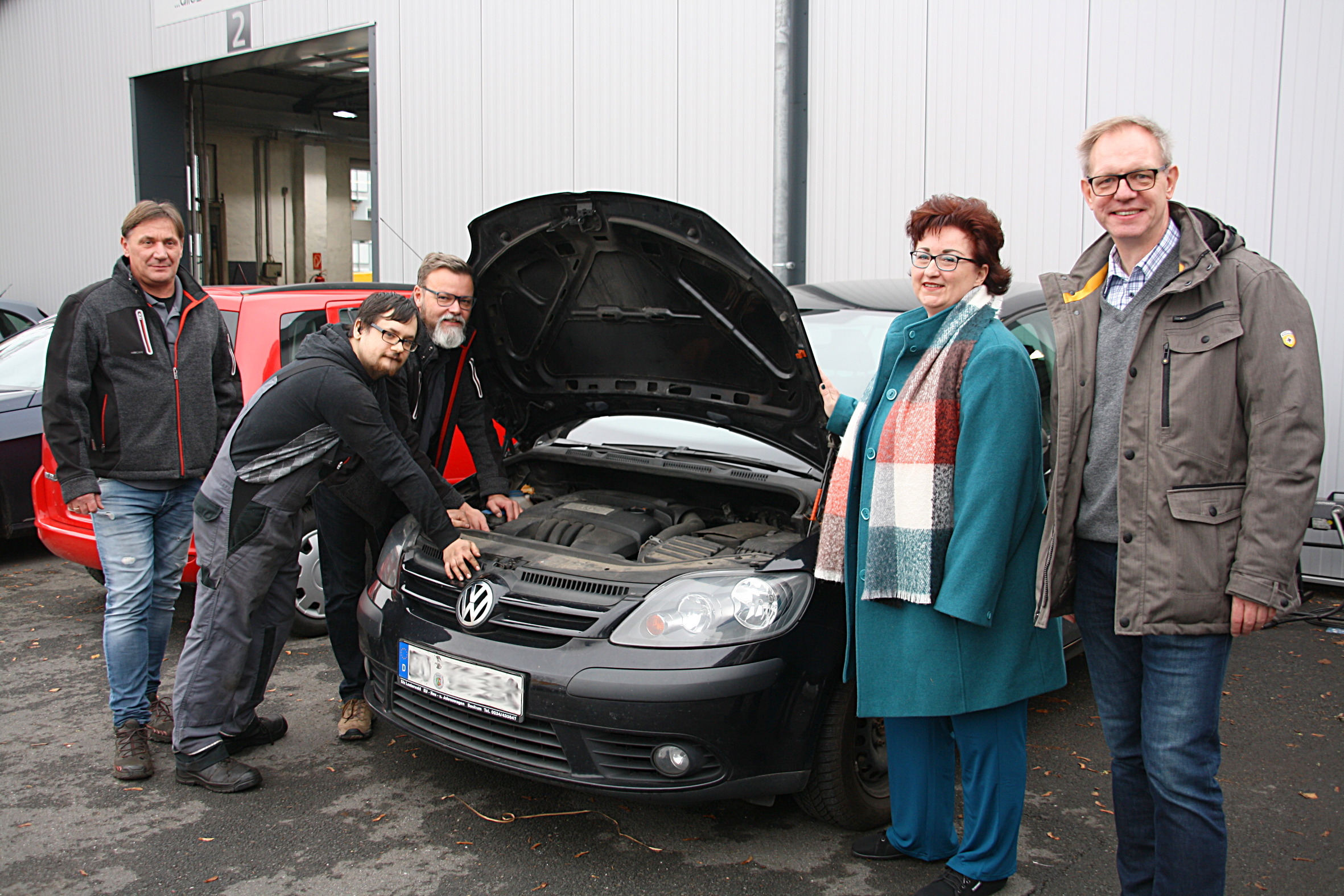 Kfz-Technikermeister Thomas Stachowiak (v.l.), Kfz-Mechatroniker-Azubi Pascal Wiegand, Kfz-Mechanikermeister Michael Dittmar, Arbeitsvermittlerin Stephanie Graul und Inklusionskoordinator Andreas Pauls auf dem Hof des Ausbildungsbetriebs Dittmar und Stachowiak.