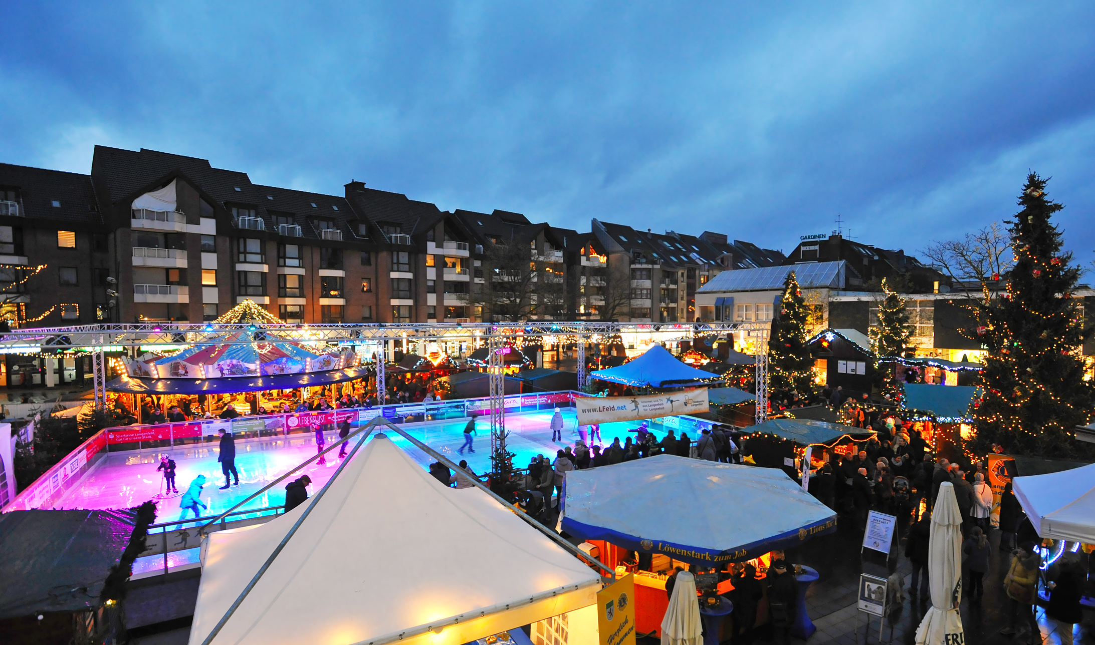 Blick von oben auf die Eislaufbahn im Herzen des Weihnachtsdorfes auf dem Marktplatz. Jung und Alt nutzten die Gelegenheit, sich die Schlittschuhe anzuziehen und die ein oder andere Runde zu drehen. 250 Quadratmeter misst die Stadtwerke-L.Feld.net-Eislaufbahn. Weitere Infos über das Angebot auf zwei Kufen gibt es unter www.lokalkompass.de/event/langenfeld.