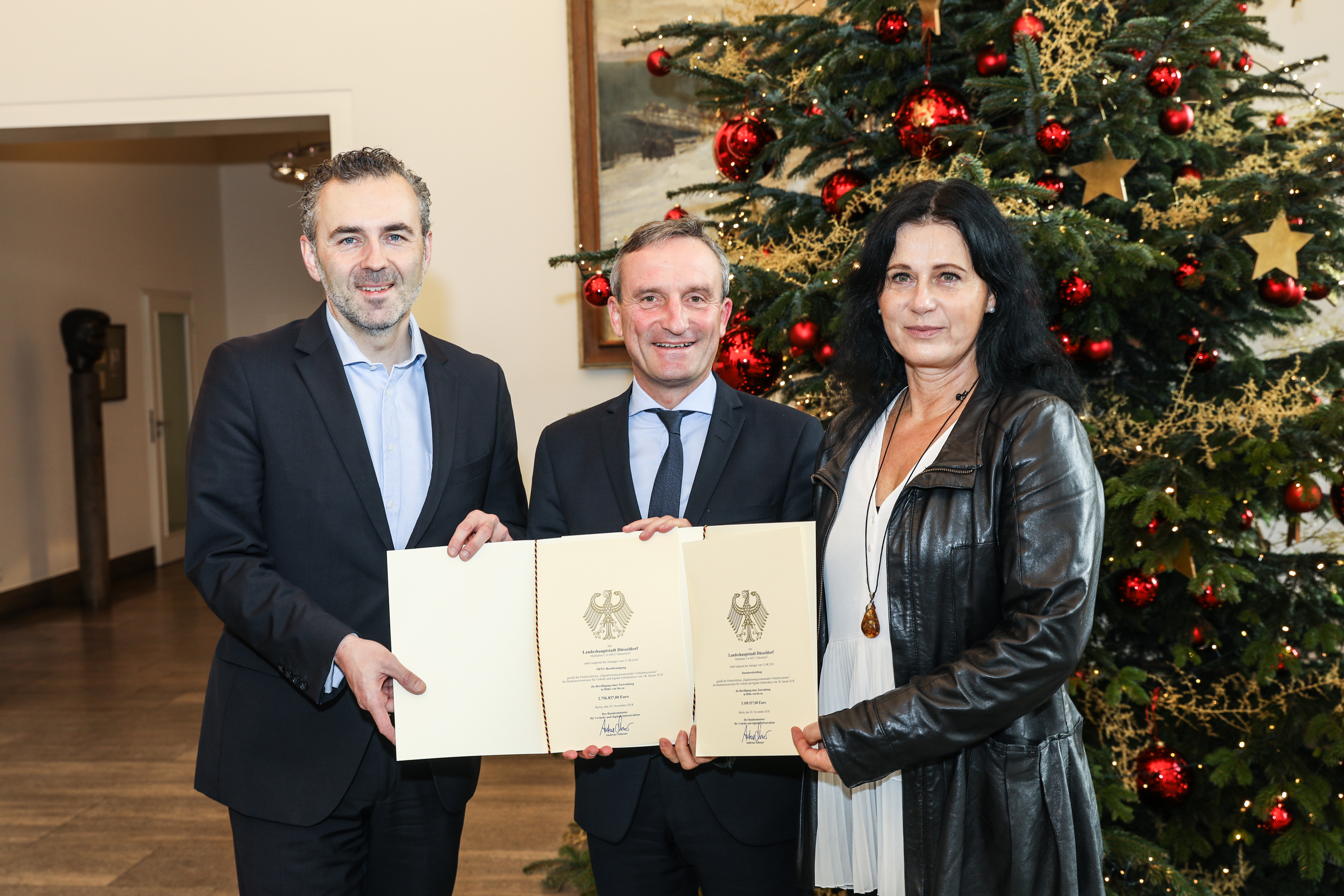 Oberbürgermeister Thomas Geisel (Mitte) und Verkehrsdezernentin Cornelia Zuschke haben zwei Förderbescheide aus dem "Sofortprogramm Saubere Luft" des Bundes von dem Düsseldorfer Bundestagsabgeordneten Thomas Jarzombek entgegen genommen. Foto: Landeshauptstadt Düsseldorf, Melanie Zanin