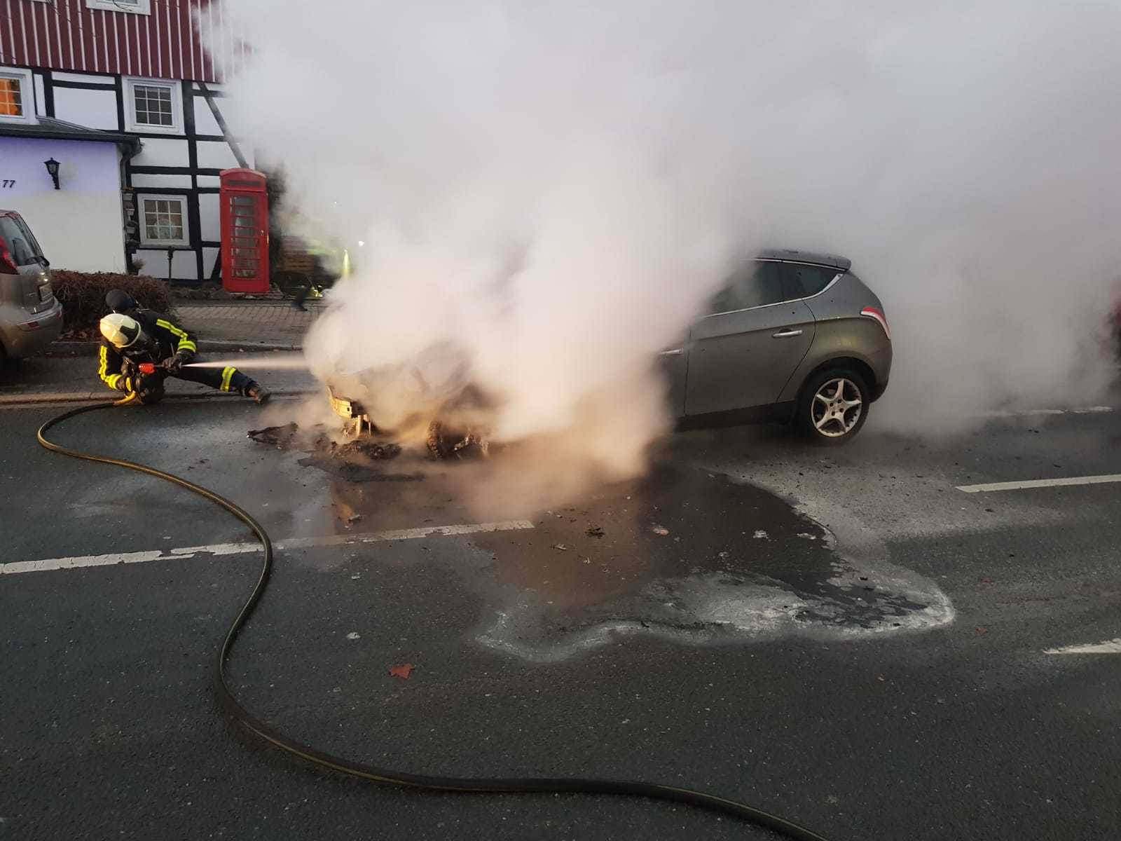 Unter Atemschutz löscht die Feuerwehr den brennenden PKW