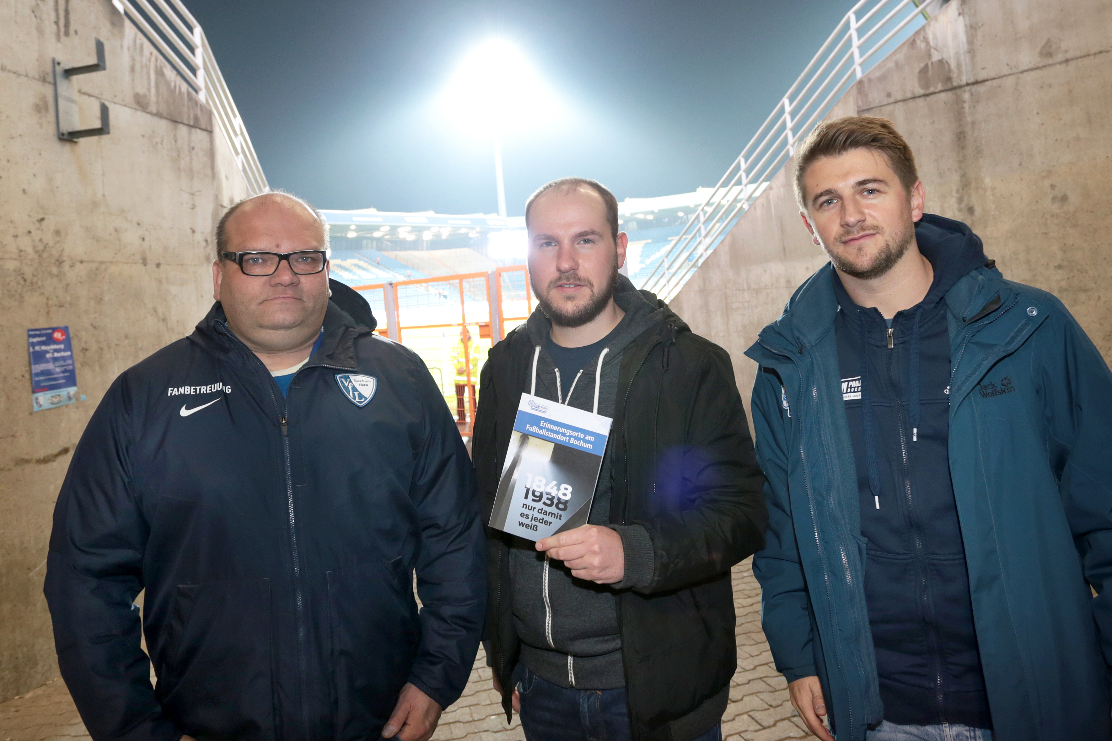 VfL-Fanbeauftragter Dirk Michalowski, Thorben Sommer und Florian Kovatsch (v.l.n.r.) vom Fanprojekt Bochum erinnern mit der Broschüre „1848.1938 – Nur, damit es jeder weiß“ und geführten Rundgängen an die Geschichte des VfL Bochum und der Stadt während des Nationalsozialismus'.