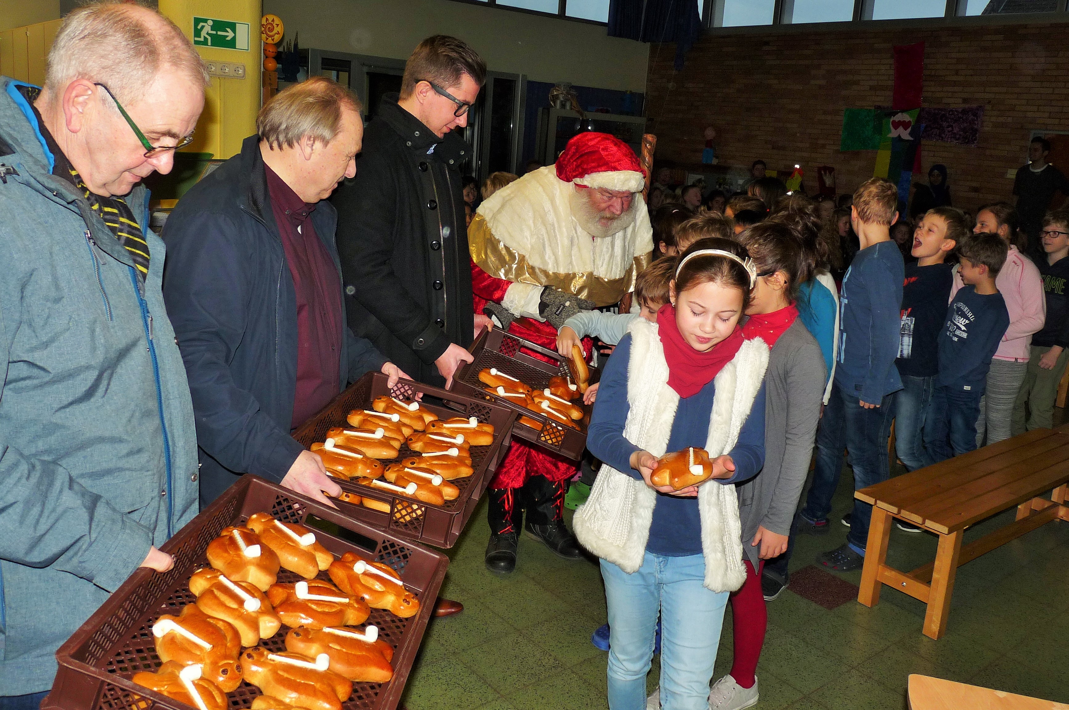 Alle Hände voll zu tun hatten HSC-Geschäftsführer Günter Schütte, Vizepräsident Udo Speer und Präsident Sebastian Benett (von links), um den Nikolaus bei der Verteilung der Stutenkerle an der Aloysiusschule zu unterstützen.