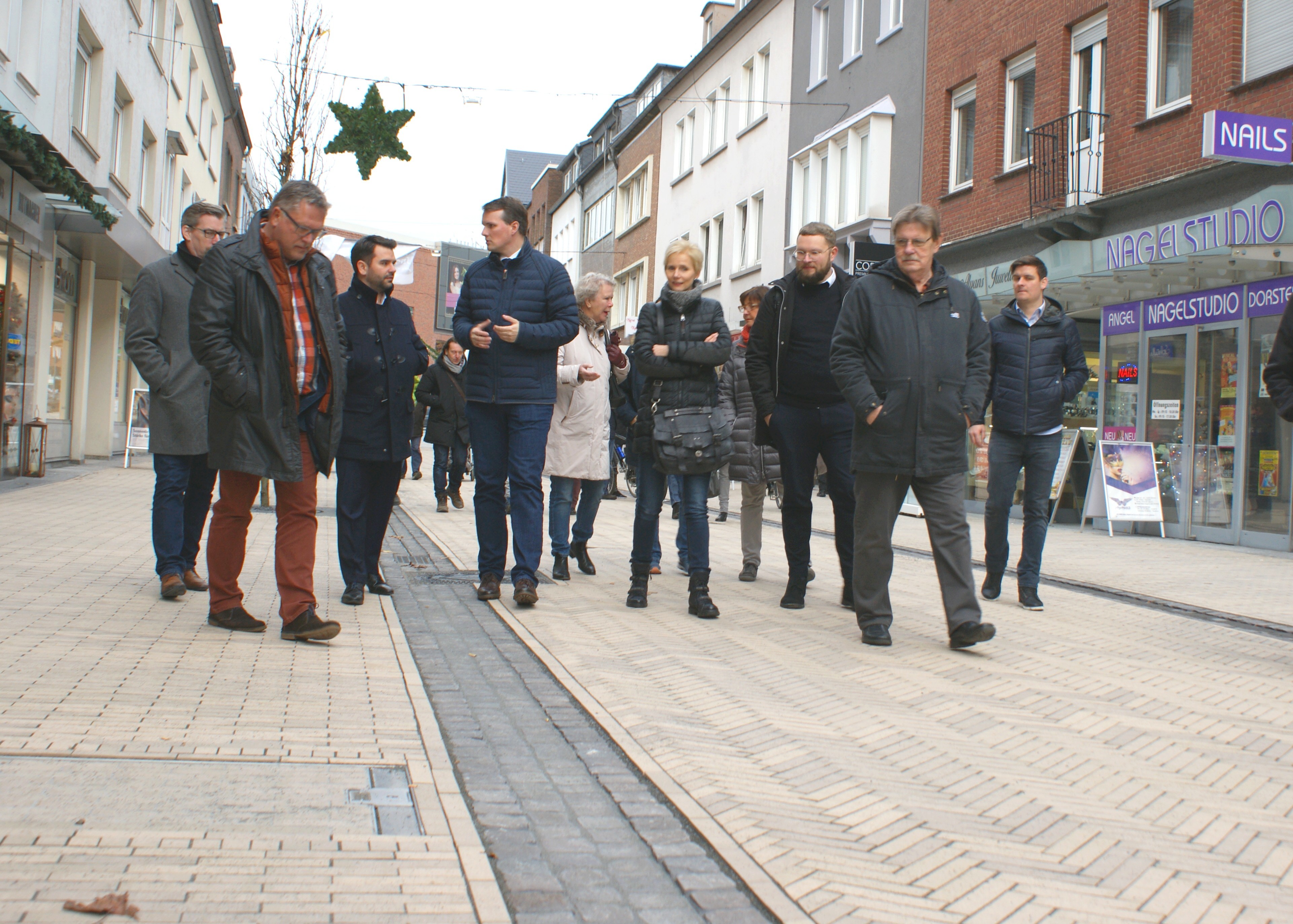 Stadtbaurat Holger Lohse (2.v.l.) und Bürgermeister Tobias Stockhoff (4.v.l.) erkunden gemeinsam mit Anliegern, Geschäftsleuten und beteiligten Firmen den fertig gestellten ersten Bauabschnitt der Erneuerung der Fußgängerzone.