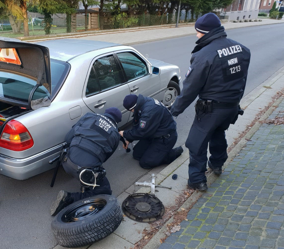 Die Beamten der Bereitschaftspolizei wechseln den Reifen des Seniors (96). Der bedankt sich anschließend mit einem Handkuss.