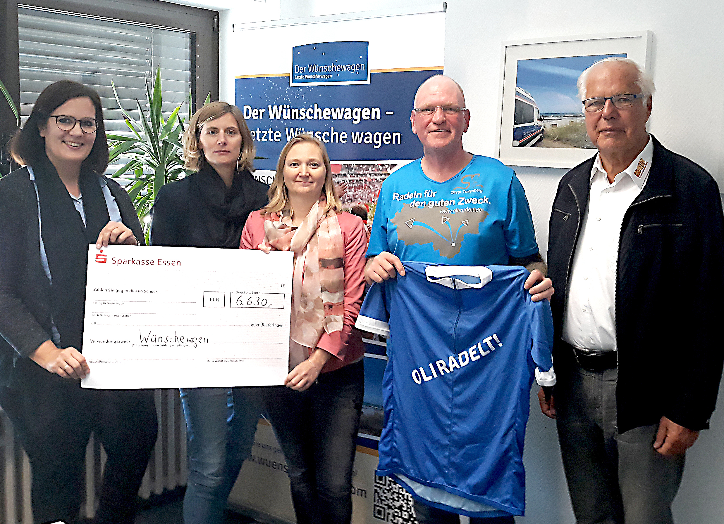Oli Trelenberg (3.v.r.) und Wilhelm Müller, Vizepräsident des ASB Deutschland, bei der der Scheckübergabe beim Arbeiter-Samariter-Bund in Essen.