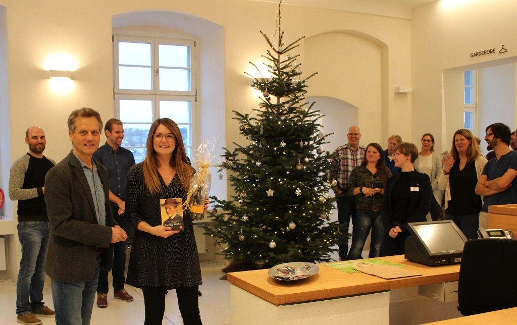 Museumsleiter Dr. Schulte-Hobein überreicht das Präsent an die 5000. Besucherin Anna Rickenbrock von der Firma Trilux.
