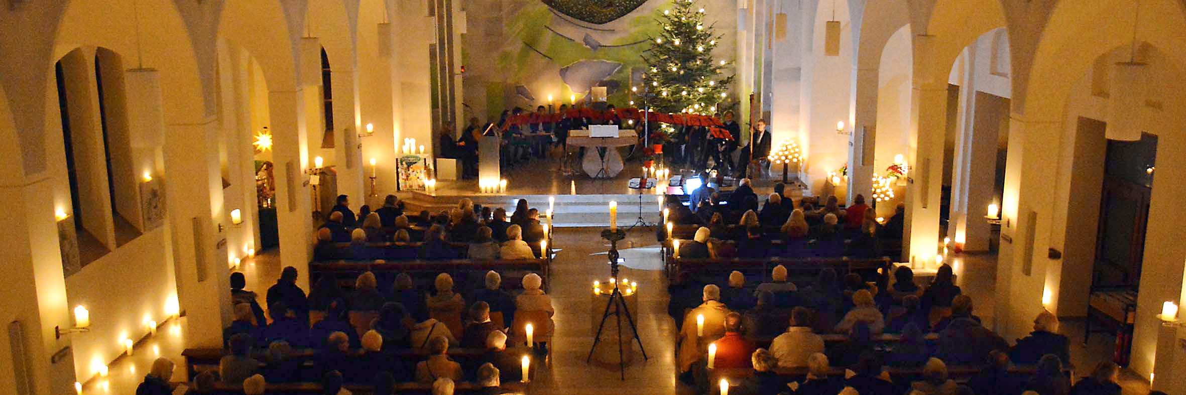 Ein eindrucksvolles Bild bot sich von der Empore in die stimmungsvoll nur mit Kerzen beleuchtete Kirche und auf den Altarraum mit dem Weihnachtsbaum, Chören und Ensembles.