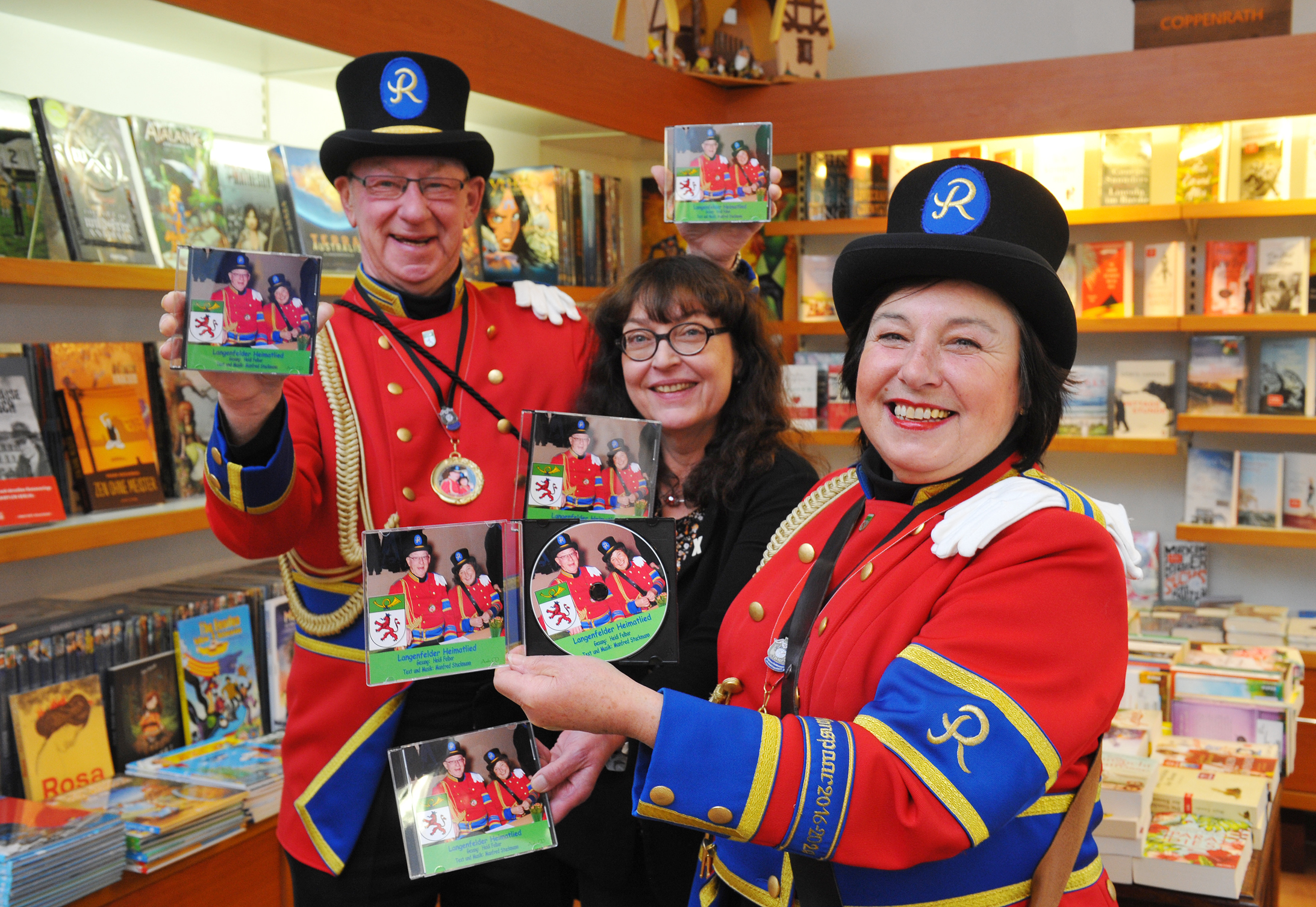 Das Langenfelder Heimatlied, gesungen von Heidi Felbor (Christel von der Post), gibt es auf CD ab sofort in der Buchhandlung Markett. Auf dem Foto von links: Postillon Josef Felbor, Buchhändlerin Hiltrud Markett und Christel von der Post Heidi Felbor.