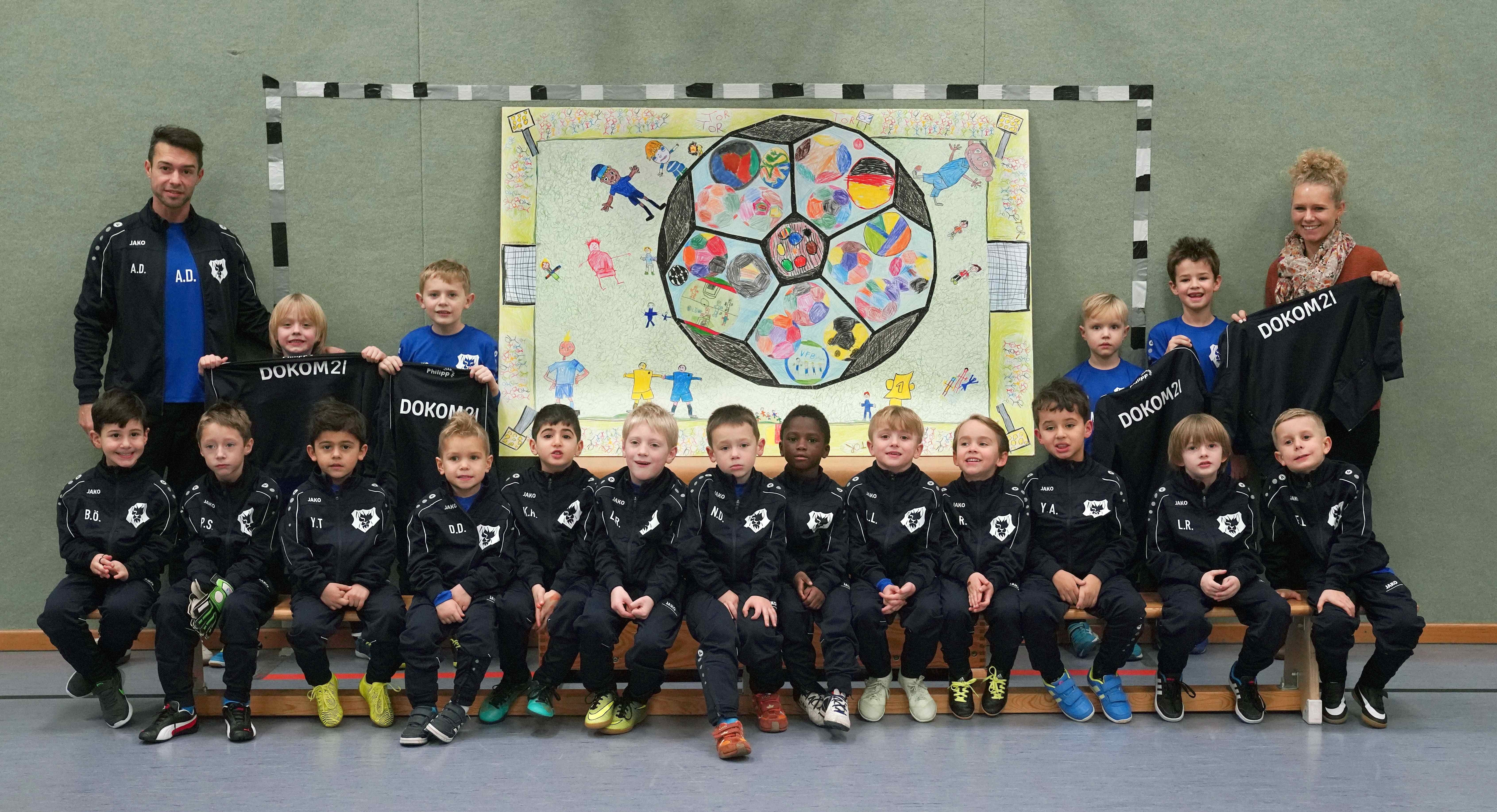 Das von der Bambini-Mannschaft des VfB Frohnhausen gemalte Bildmotiv wurde jetzt in Anwesenheit von Helen Waltener (rechts), Marketing-Mitarbeiterin von DOKOM21, Abdullah Deniz (links), Trainer der Bambini-Mannschaft, und der kleinen Künstler als großformatiger Digitaldruck an die DOKOM21 Technikstation an der Raumerstraße 38 in Frohnhausen angebracht.