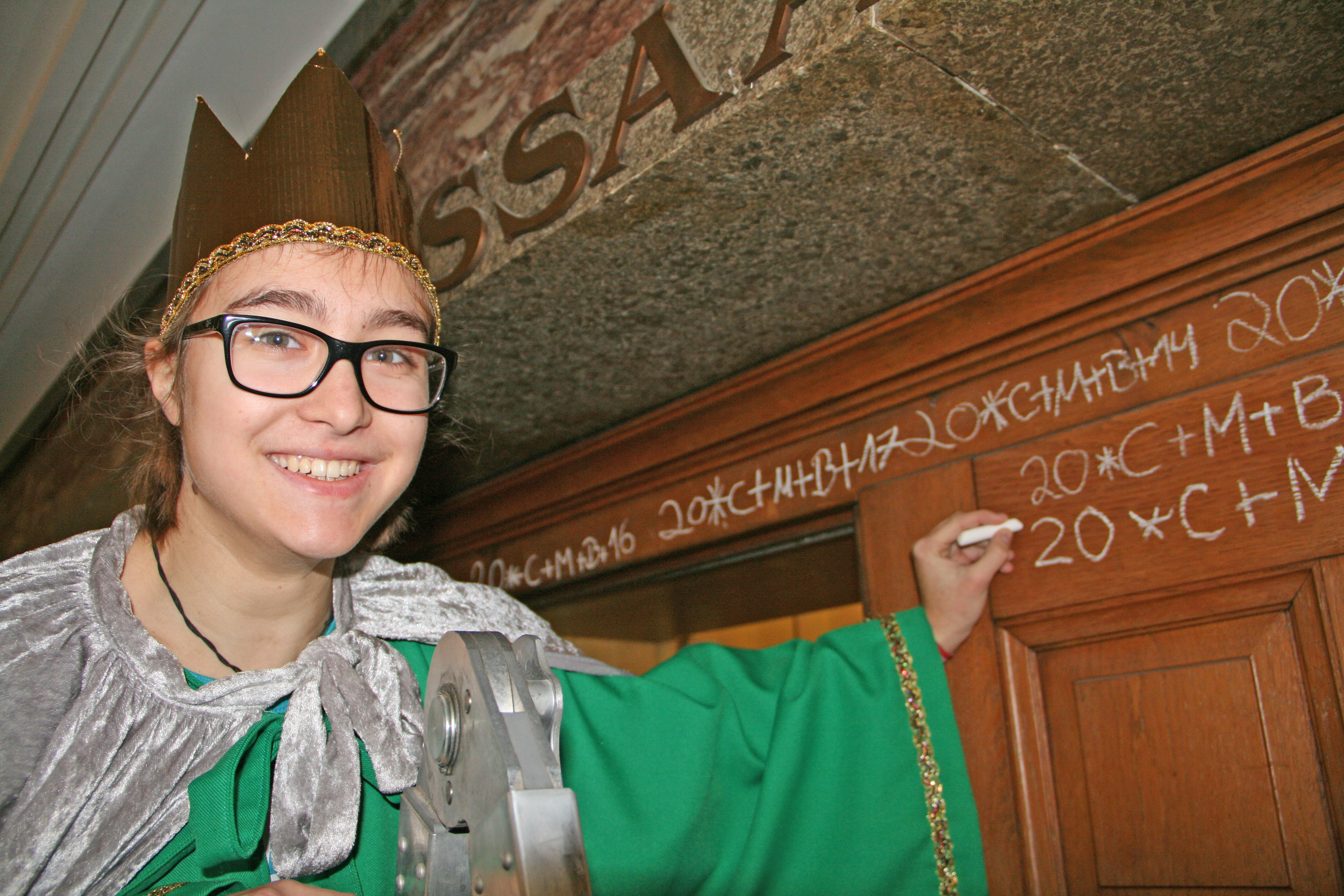 Sternsinger-Kind Ursula schriebt den Segen an die Tür des Ratssaals. Foto: Stadt Oberhausen