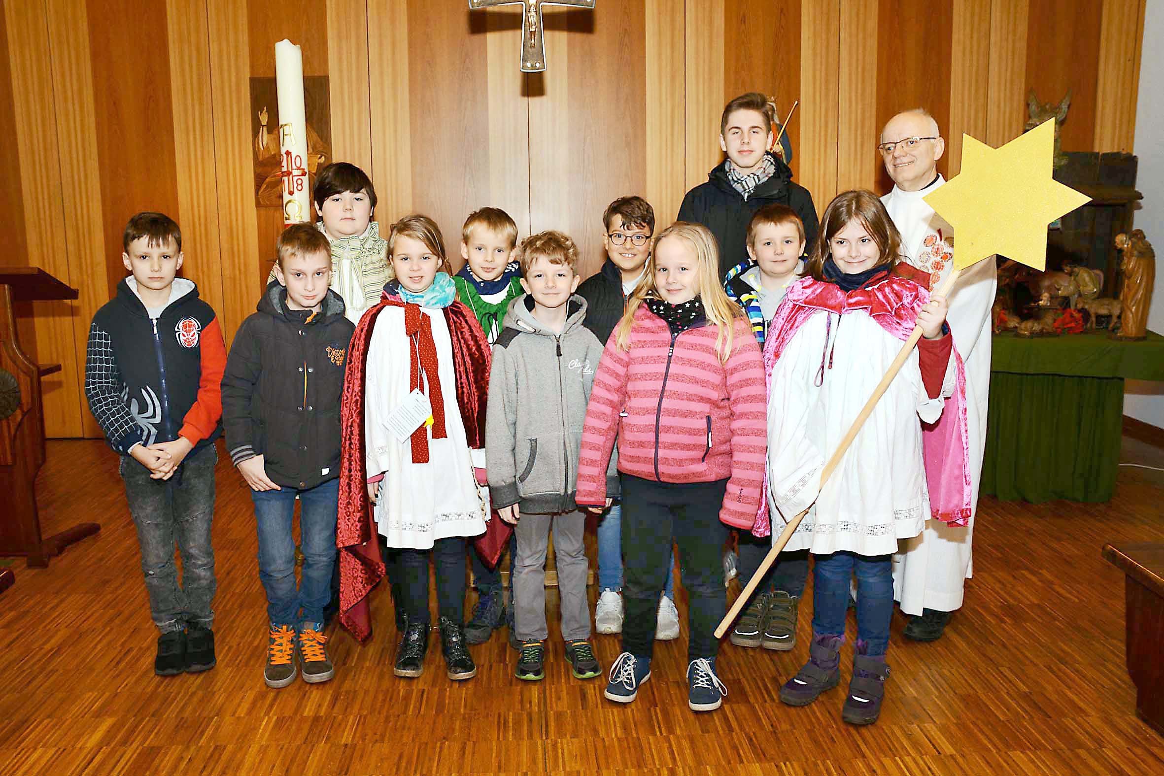 Die Sternsinger in der Oberevinger Gemeinde St. Marien bei der Aussendungsfeier in der Kapelle mit Pfarrer Leon Watzek (hinten, r.).