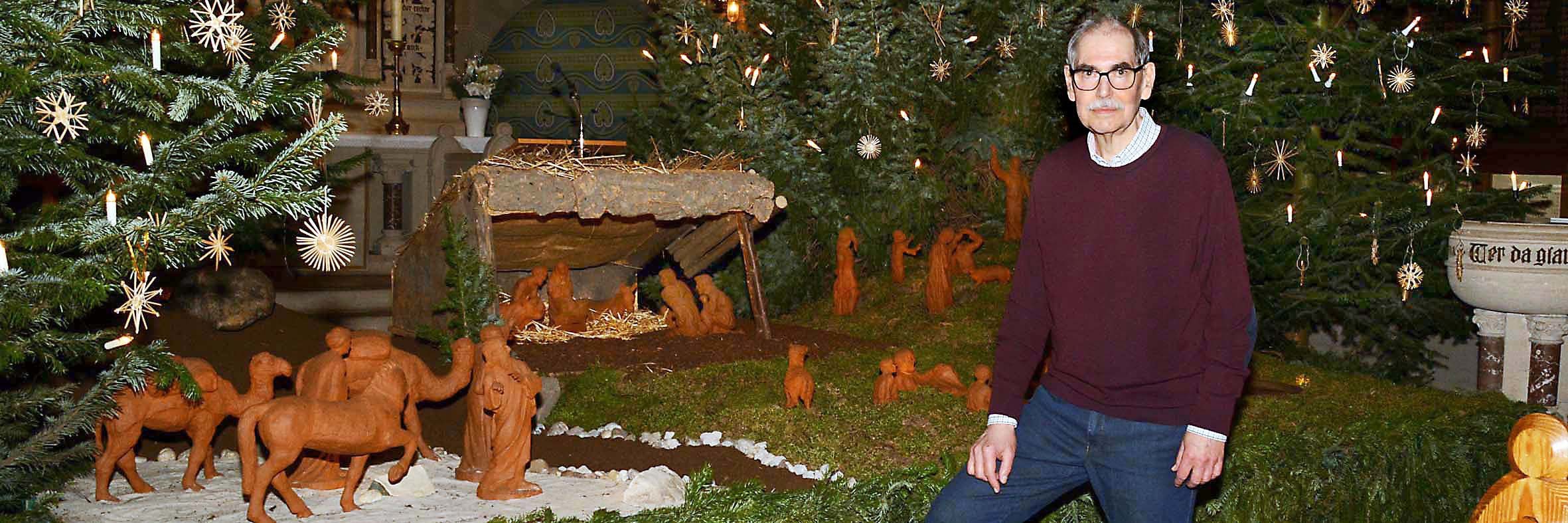 Experte Klaus Coerdt vor dem eindrucksvollen, von den Weihnachtsbäumen eingerahmten Diorama der Bourger-Krippe in der Asselner Luther-Kirche.