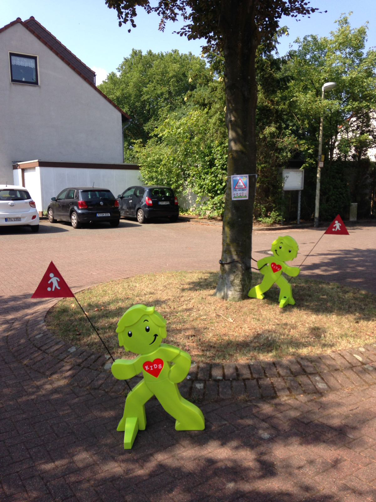 Achtung, hier spielen Kinder. Durch ihre grellgrüne Farbe und die roten Fähnchen machen die Street Buddies in der Siedlung Clemens-Schmeck-Straße auf merksam: Mehr Sicherheit für Kinder und Senioren.