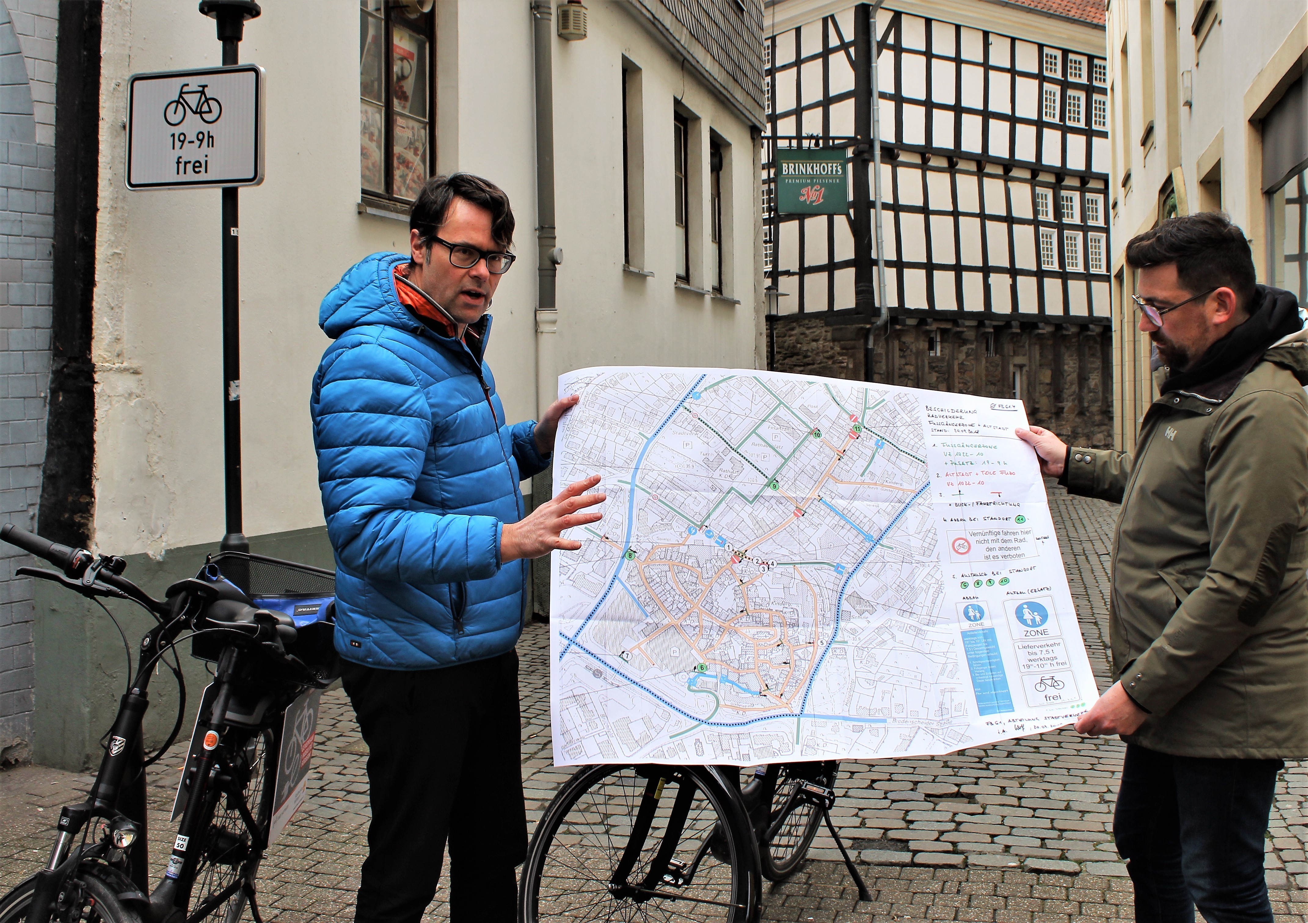 Baudezernent Jens Hendrix und Thomas Hoeland, stellv. Fachbereichsleiter, erklären, wo an welchen Stellen die neuen Schilder aufgestellt wurden. Links im Bild eines der neuen Schilder. Foto: Pielorz