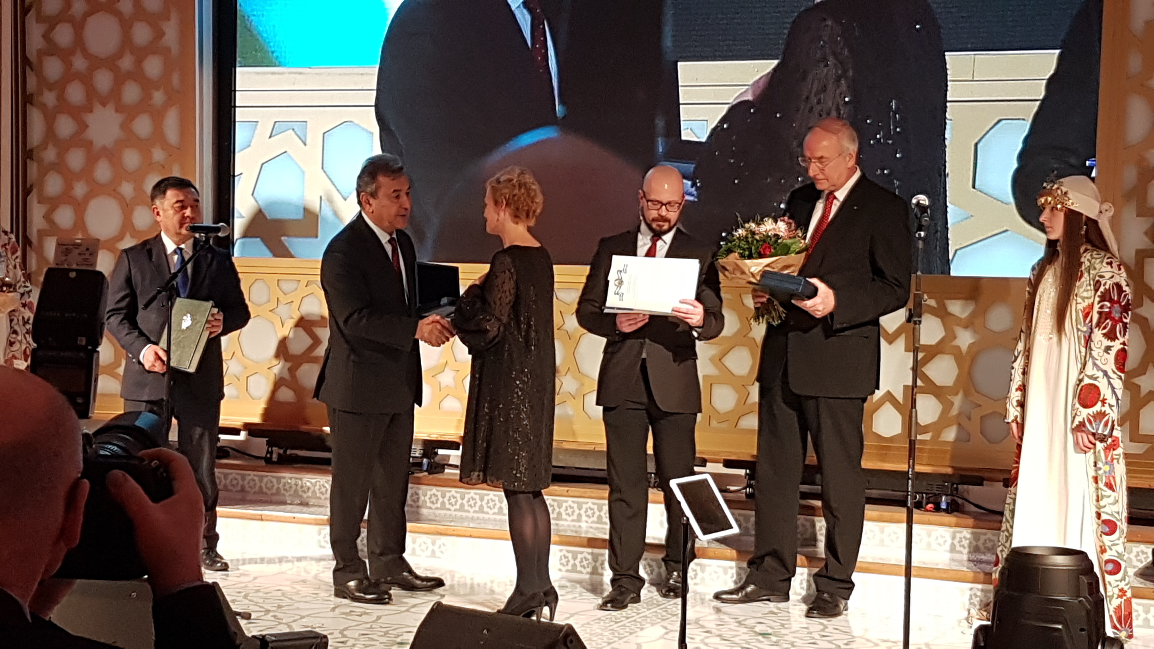 Botschafter Nabijon Kasimov überreicht die Auszeichnung an Friedensdorf-Mitarbeiterin Claudia Peppmüller. Foto: Friedensdorf