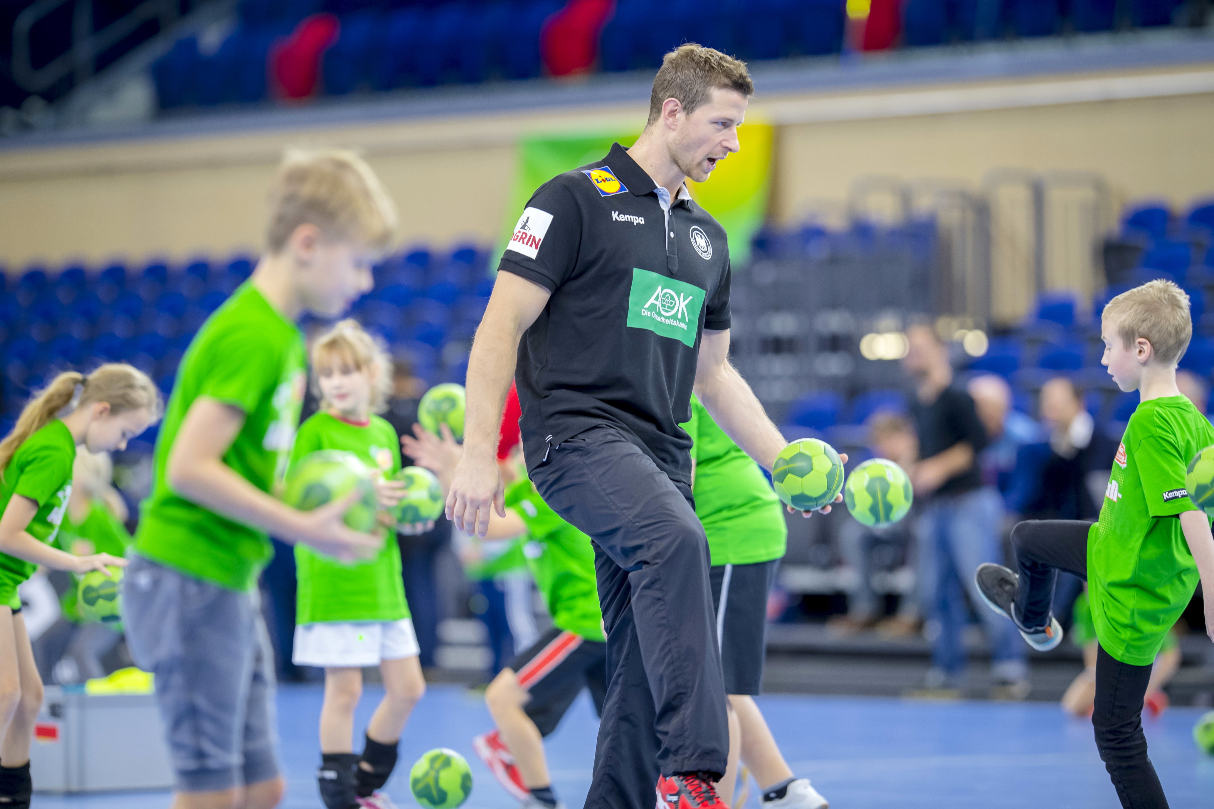 Beim AOK Star-Training zeigt Handball-Star Martin Strobel den Schülerinnen und Schülern verschiedene Dribbel- und Schritt-Techniken.
