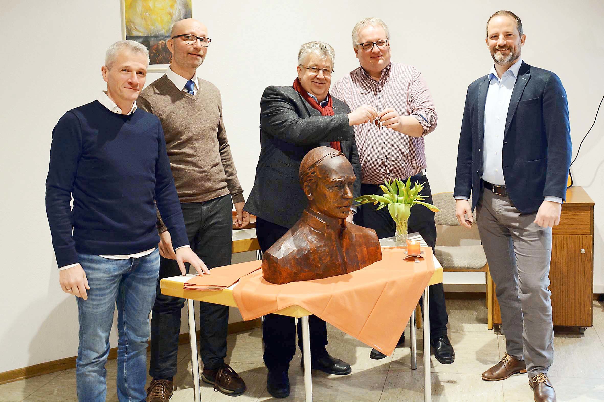 Das Foto zeigt die Übergabe der Kolping-Schlüssel vom alten - Julius Wandelt (3.v.l.) - an den neuen - Andre Wellmann (2.v.r.) - verantwortlichen Ansprechpartner des Kurler Kolping-Leitungsteams. Mit im Bild versammelt hinter der Büste Adolph Kolpings (v.l.n.r.): Jan Zimmermann, Andreas König und Dr. Mark Ölmüller.