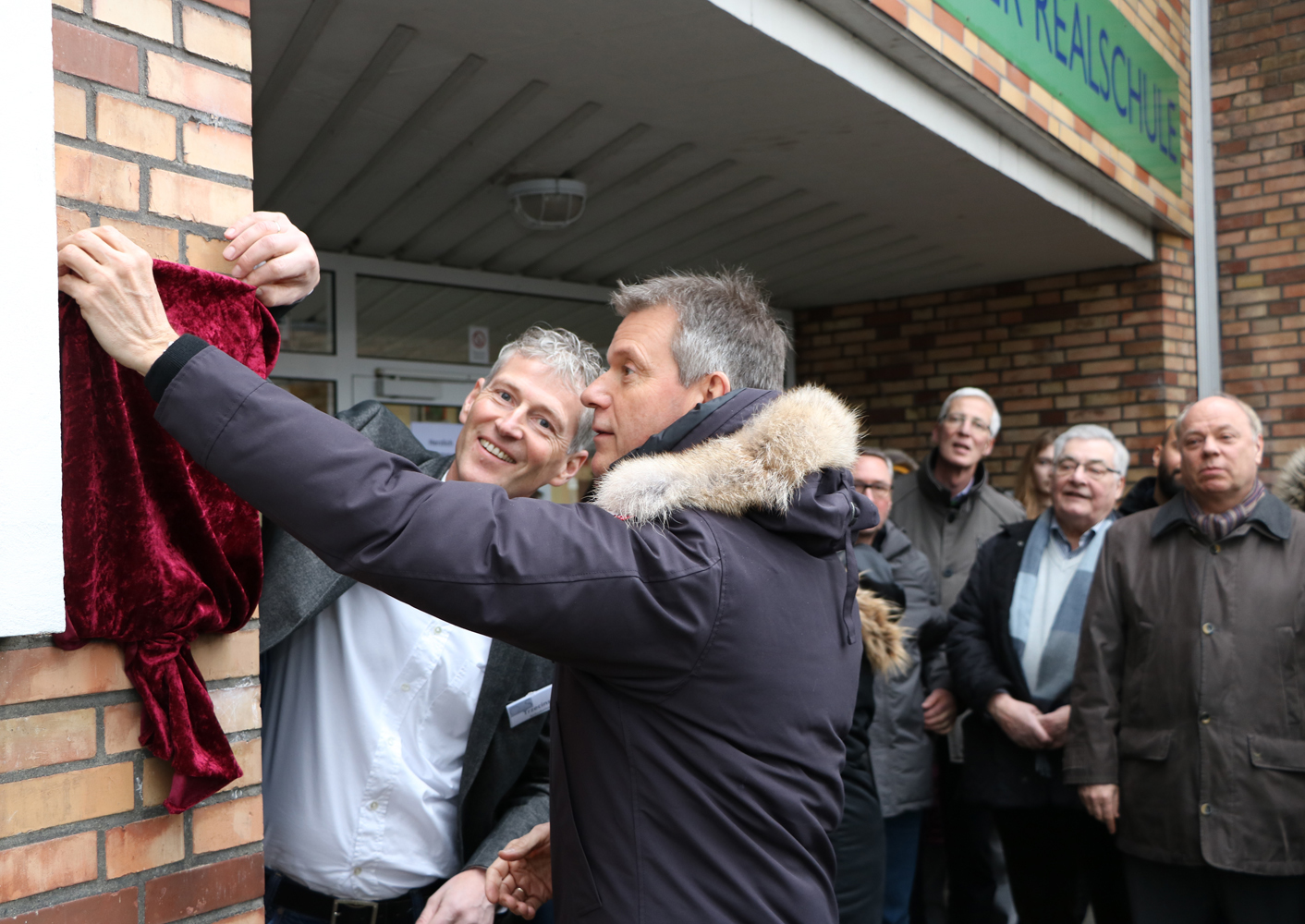 Gemeinsam enthüllten Schulleiter Lars Trzecinski und Bürgermeister Christoph Tesche (r.) die Gedenktafel am Eingang der Otto-Burrmeister-Realschule an der Maybachstraße.