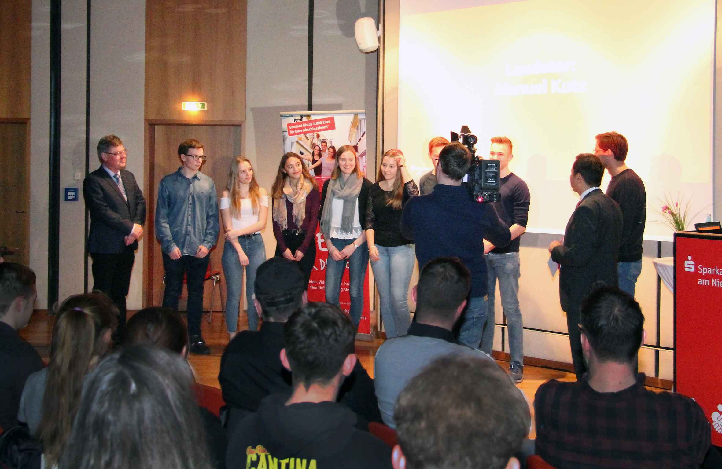 Hollywood-Atmosphäre bei der Preisverleihung für die Sieger des Videowettbewerbs der Sparkasse am Niederrhein im Heinrich-Goldberg-Saal. Vorstandsvorsitzender Giovanni Malaponti verteilte viel Knete für die Fete. Die Schülerinnen und Schüler des Stiftsgymnasiums und ihr Rektor Franz-Josef Klaßen freuten sich über den Sieg und 1.000 Euro für die Abi-Kasse.