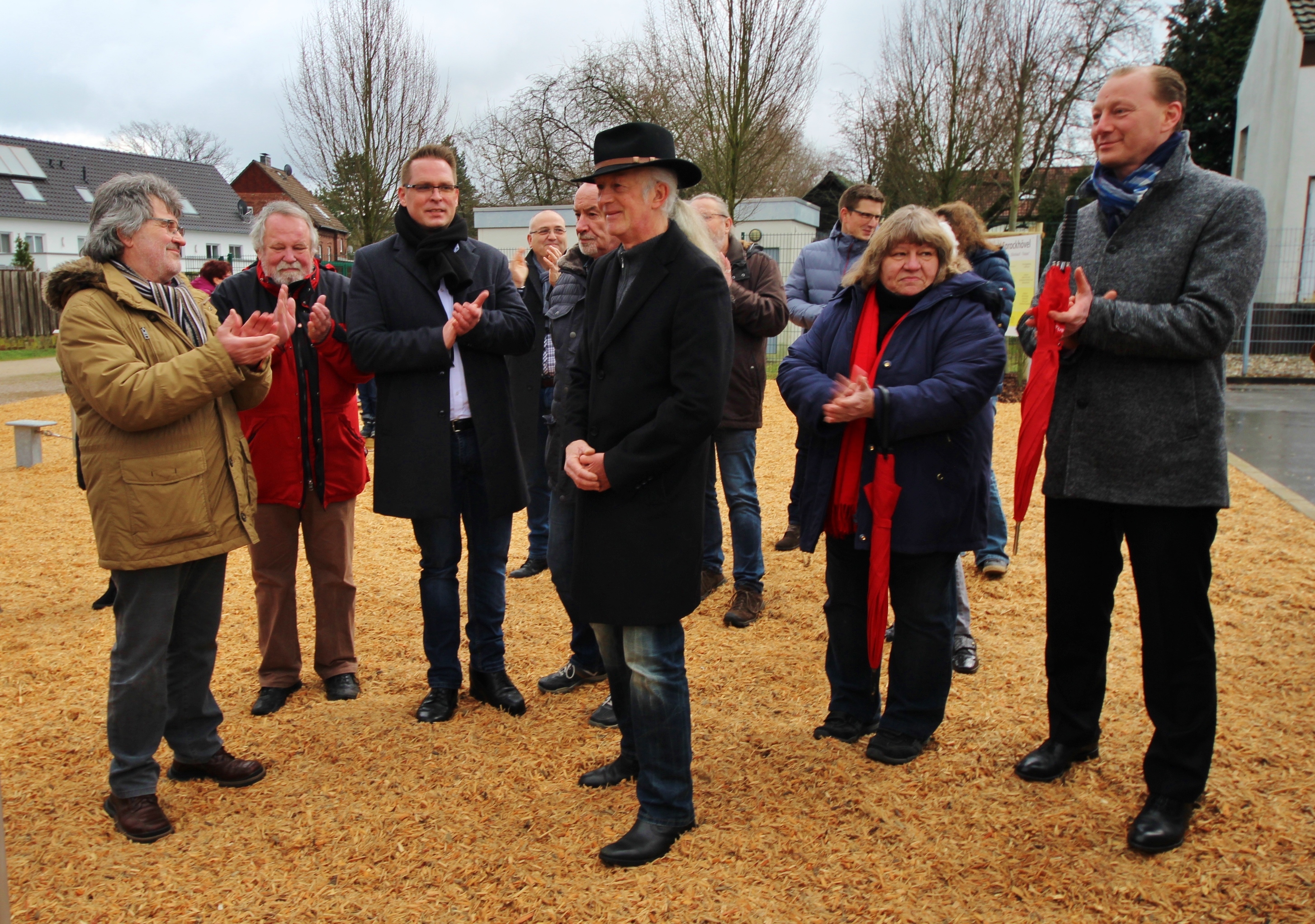 Bürgermeister Ulli Winkelmann (Mi.), Beigeordneter Volker Hoven (3.v.li.), Marion Prinz (SPD) (2.v.re.) und Sparkassendirektor Daniel Rasche (re.) bei der Einweihungsrede des Bürgermeisters zur Inbetriebnahme des neuen Mehrgenerationenspielplatzes