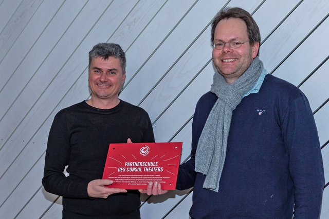 Das Consol Theater hat sich für seine Partnerschulen etwas Besonderes ausgedacht: Ein Schild samt Befestigsungsmaterial, das auf die Partnerschaft von Schule und Theater hinweist und am Besten direkt im Eingangsbereich angebracht werden sollte. Georg Kentrup übergab das Schild an Jürgen Otto. Foto: Gerd Kaemper