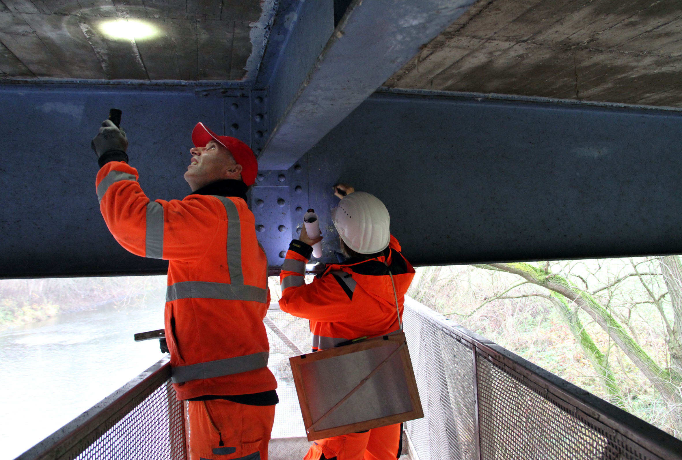Aus der direkten Nähe von unten wird die Brücke geprüft. Die Prüfer stehen dabei auf dem mobilen Teil des Untersichtgeräts, ausgestattet mit Taschenlampen, Riss-Tabellen, Hammer und Meißel. Foto Kreis RE