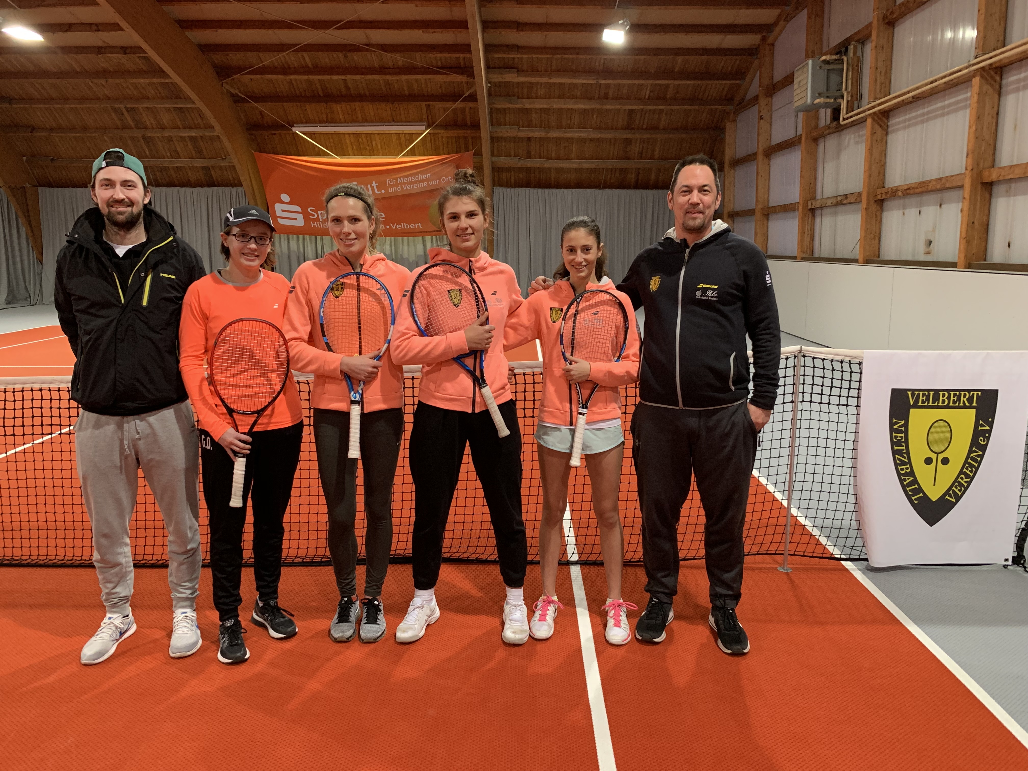Einen Gala-Auftritt haben die ersten NBV-Damen auf den orangenen Hallenteppich gelegt. Zusammen mit ihren Trainern Tom Schönenberg (außen links) und Mark Joachim (außen rechts) freut sich die Mannschaft über ihren Aufstieg in die Niederrheinliga. Von links nach rechts: Gina Dittmann, Lauren Wagenaar, Isabel Heupgen und Ana Sovilj.