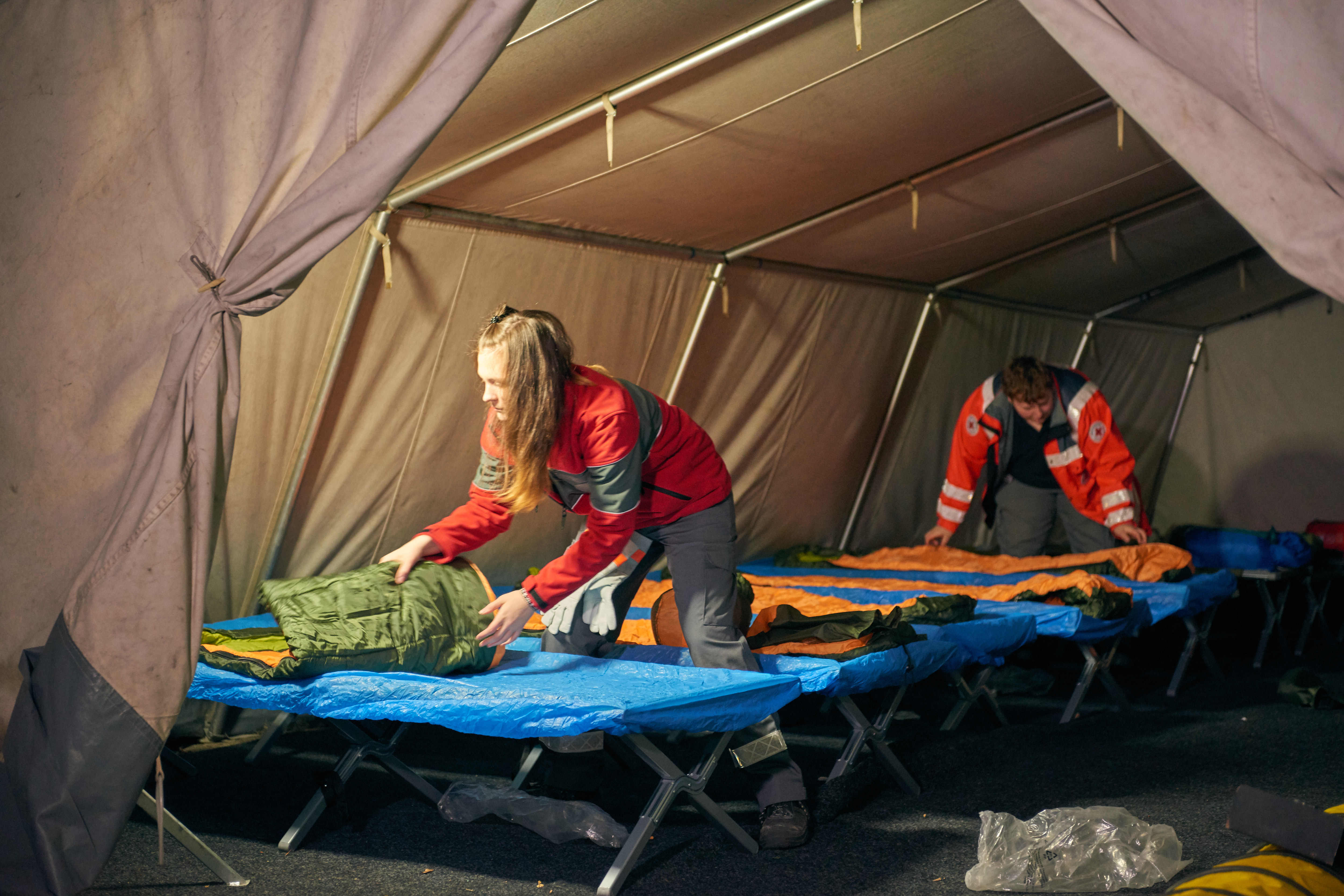 Bevor das Zelt um 21 Uhr für die Wohnungslosen öffnet, werden die Betten von den Ehrenamtlichen aufgestellt und bezogen.