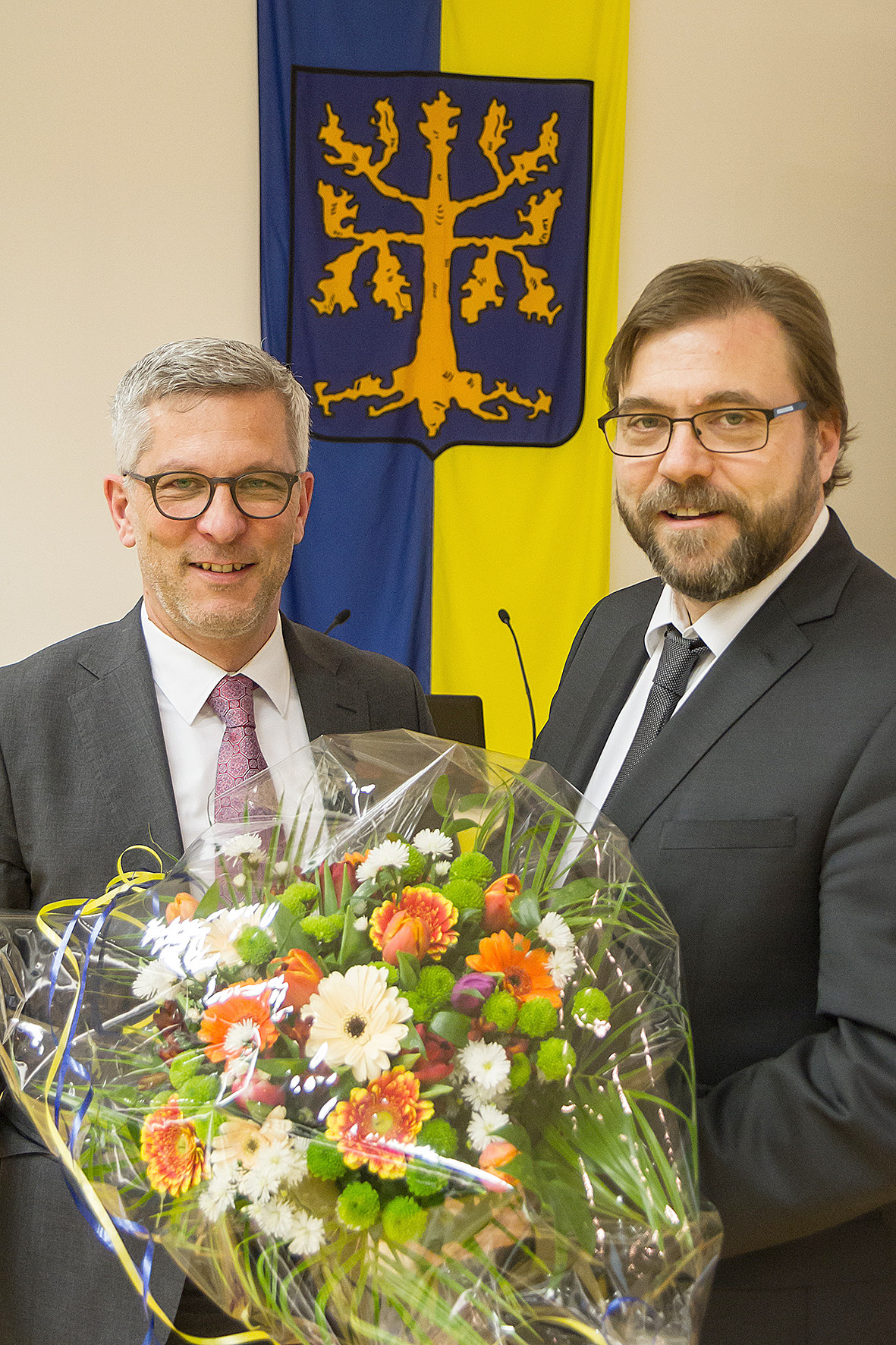 Oberbürgermeister Erik O. Schulz gratuliert Henning Keune (r.) mit einem Blumenstrauß.